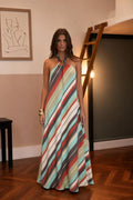 Front view of woman wearing multi-color striped halter maxi dress