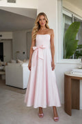 Model wearing pink strapless bow waist midi dress, front view