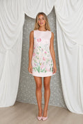 Model wearing pink botanical floral print sleeveless mini dress, front view