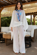 Front view of model wearing white kaftan top and wide-leg pants set