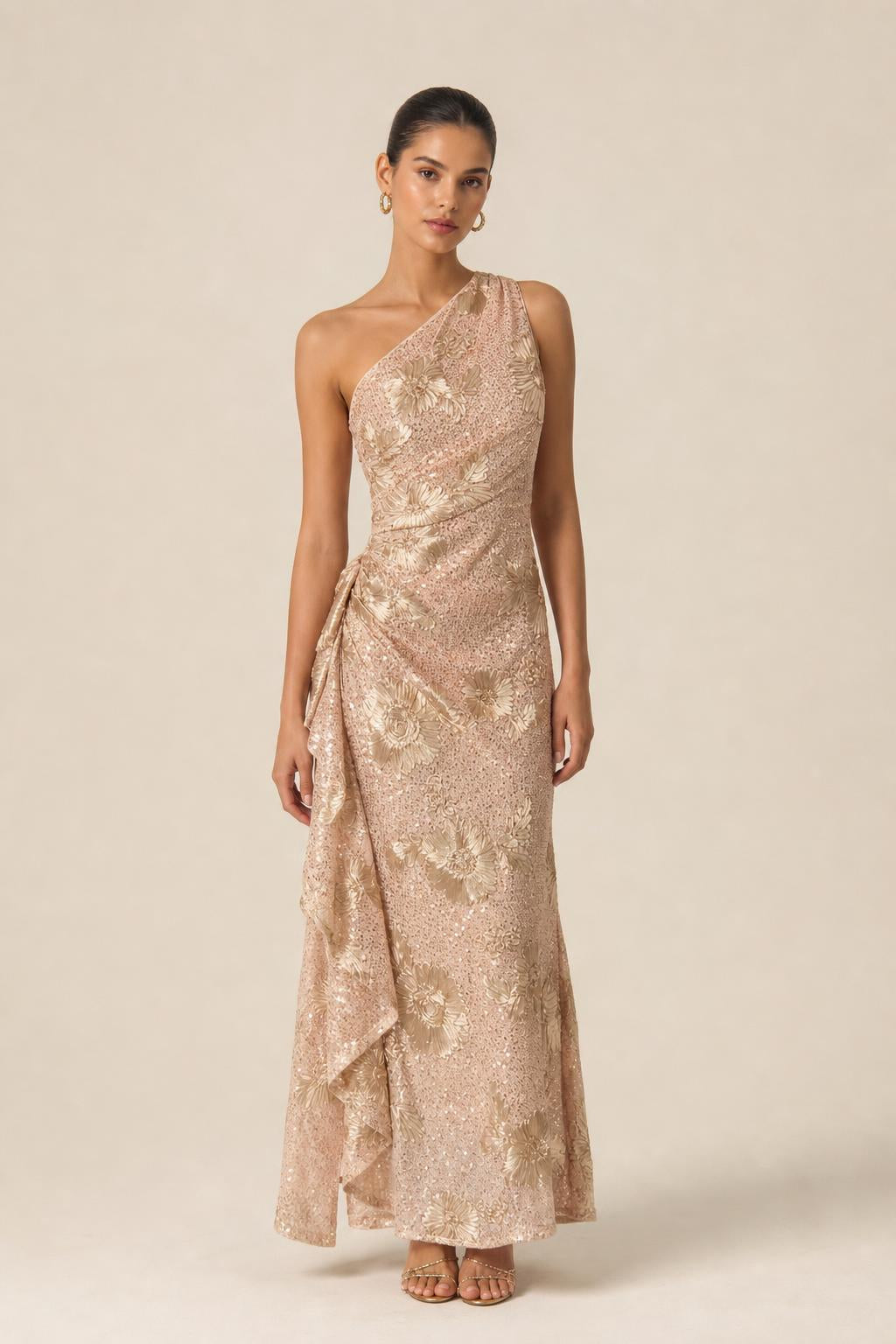Front view of champagne one-shoulder sequin evening gown with floral appliques