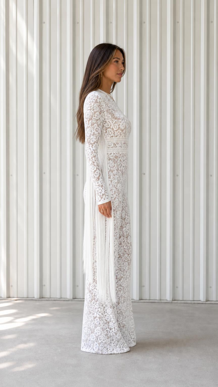 Side profile view of white lace jumpsuit with fringe detail