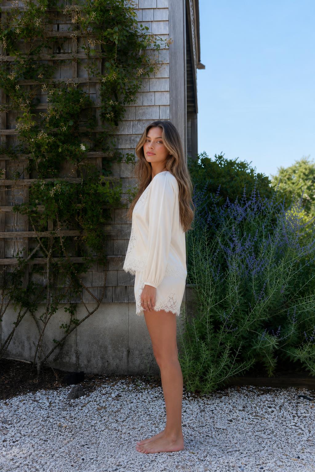 Side view of woman wearing cream lace trim lounge set