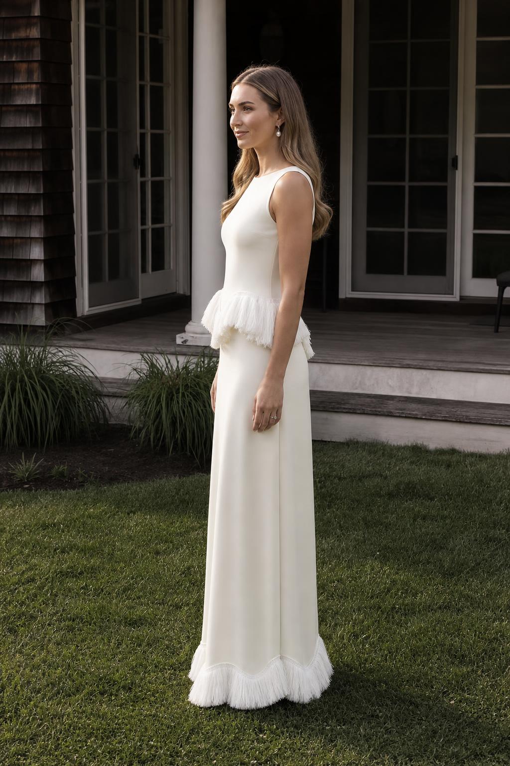 Side profile view of white fringed peplum maxi dress