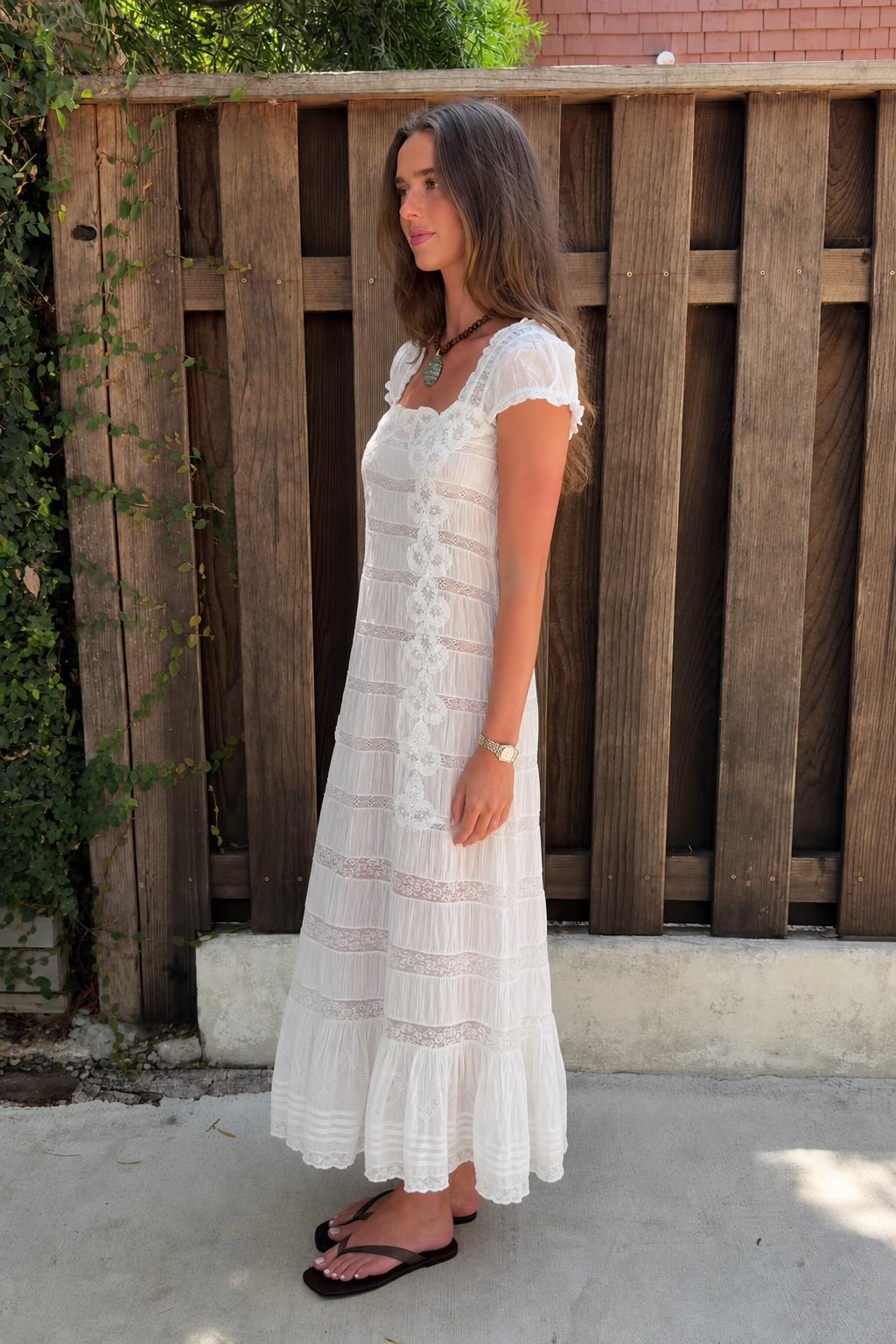 Side profile view of white lace maxi dress