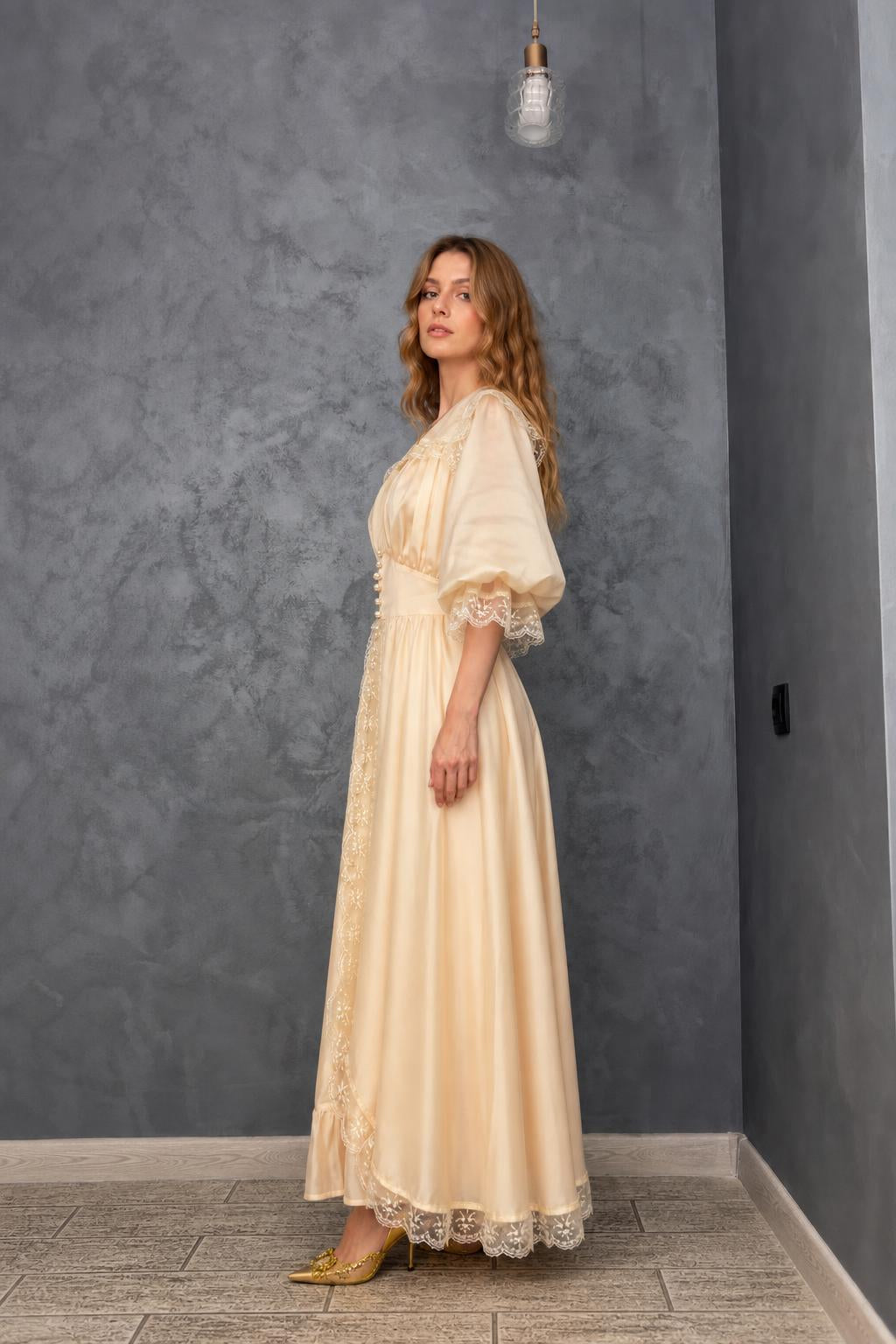 Side profile view of model in cream maxi dress
