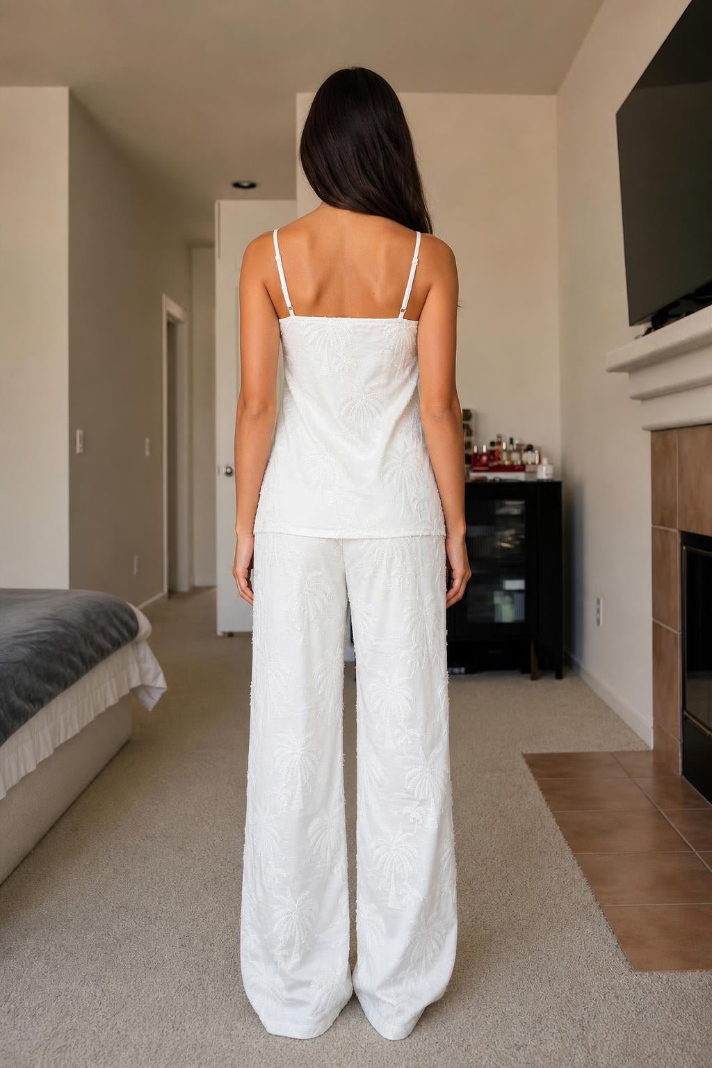 Back view of woman in white palm embroidered lounge set