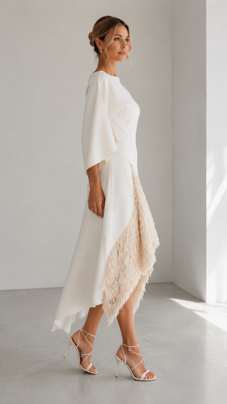 Side view of ivory occasion dress with flowing sleeve and angled hem