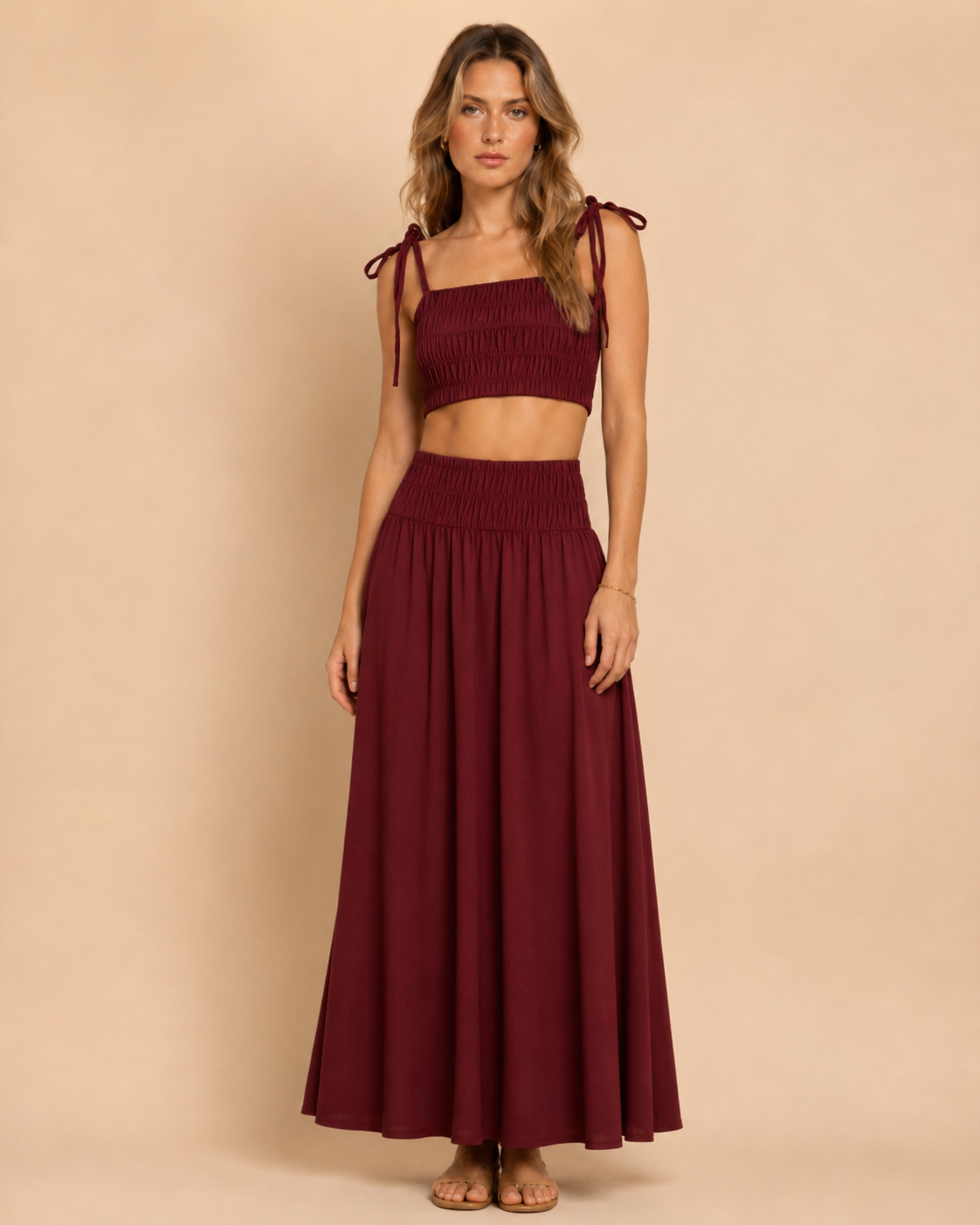 Front view of burgundy smocked tie-shoulder crop top and matching maxi skirt set