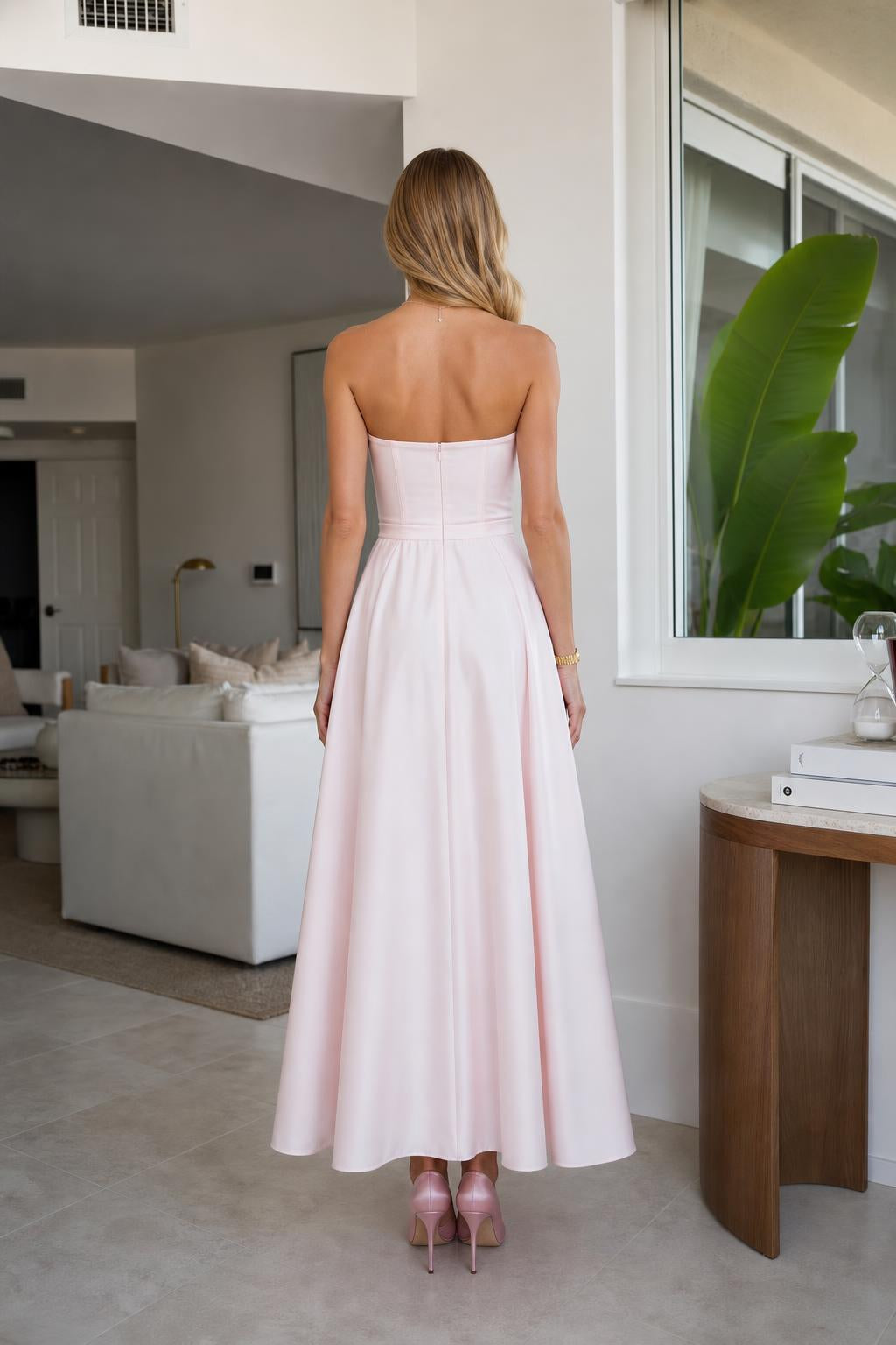 Model wearing pink strapless midi dress, back view