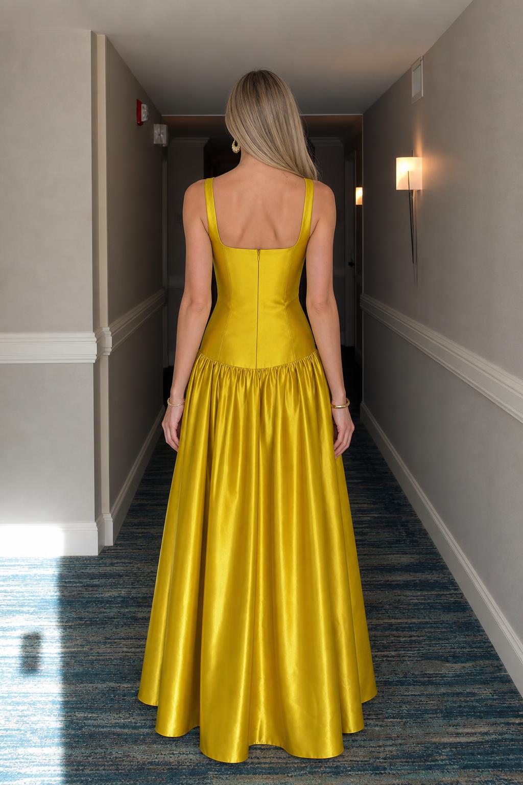 Back view of woman wearing yellow satin maxi dress