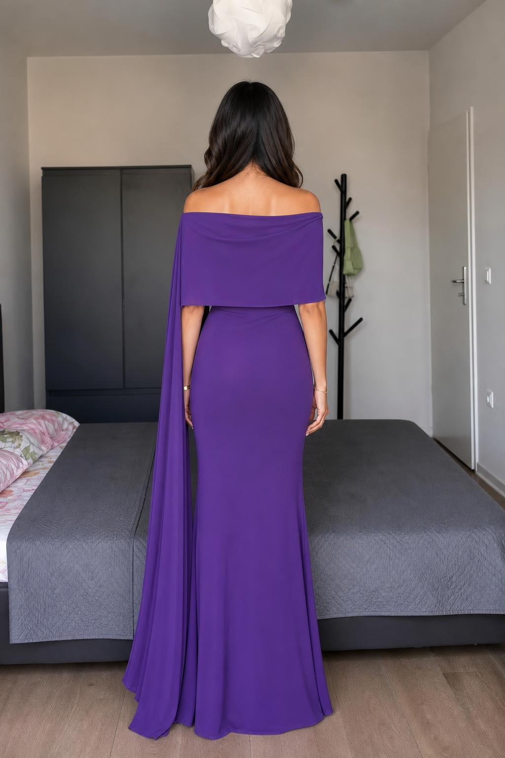 Model wearing purple off-shoulder cape maxi dress back view