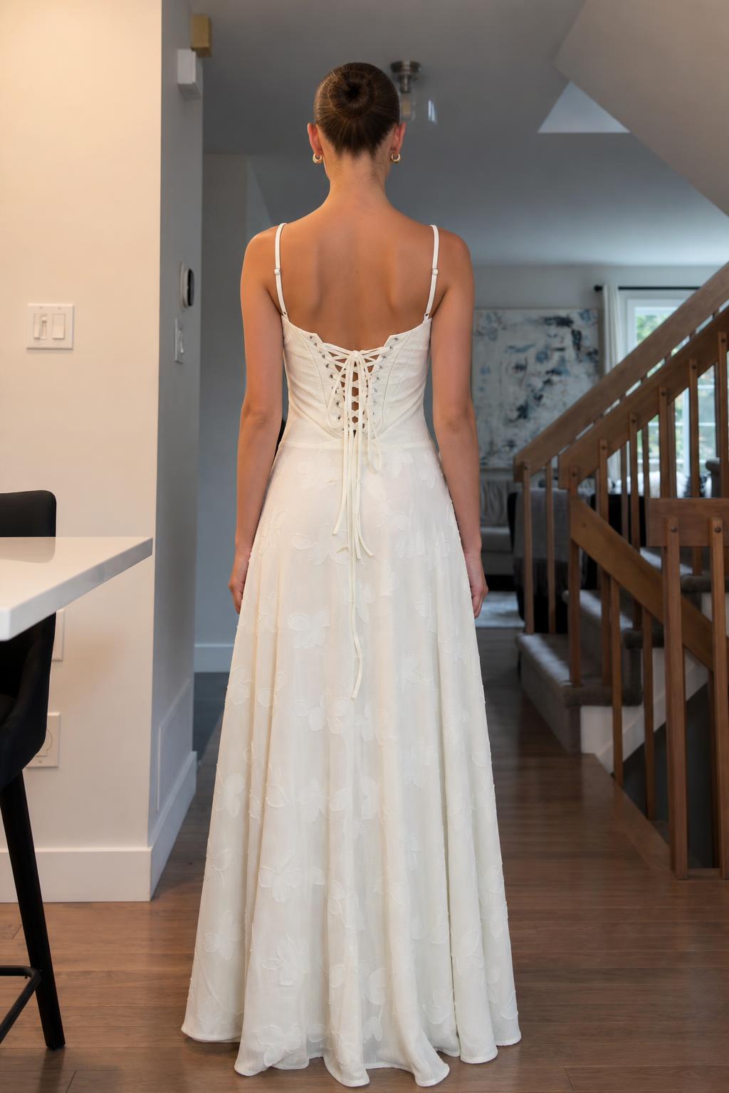 Back view of woman showing lace-up corset detail on white dress