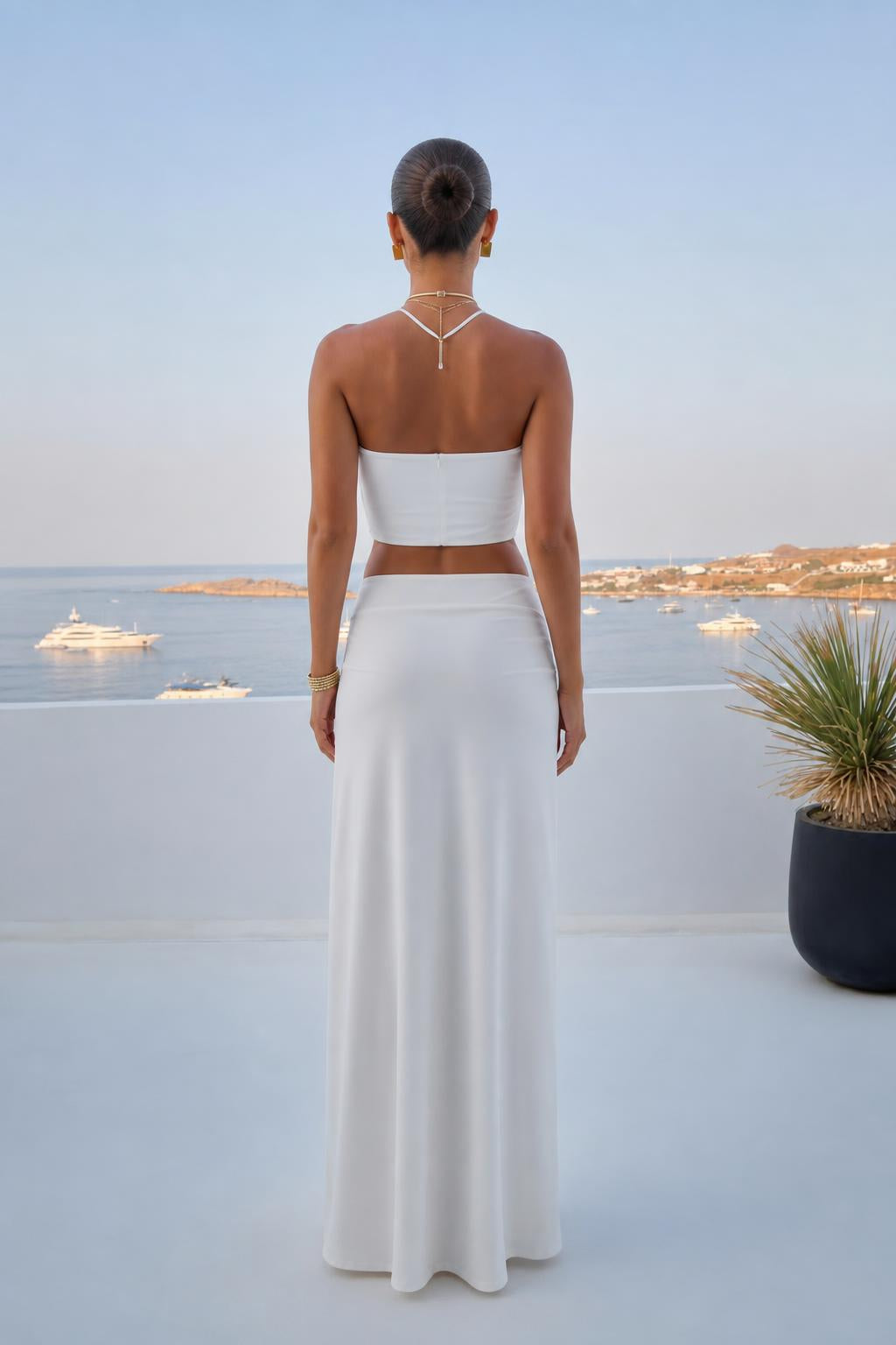 Back view of model in white two-piece maxi skirt set