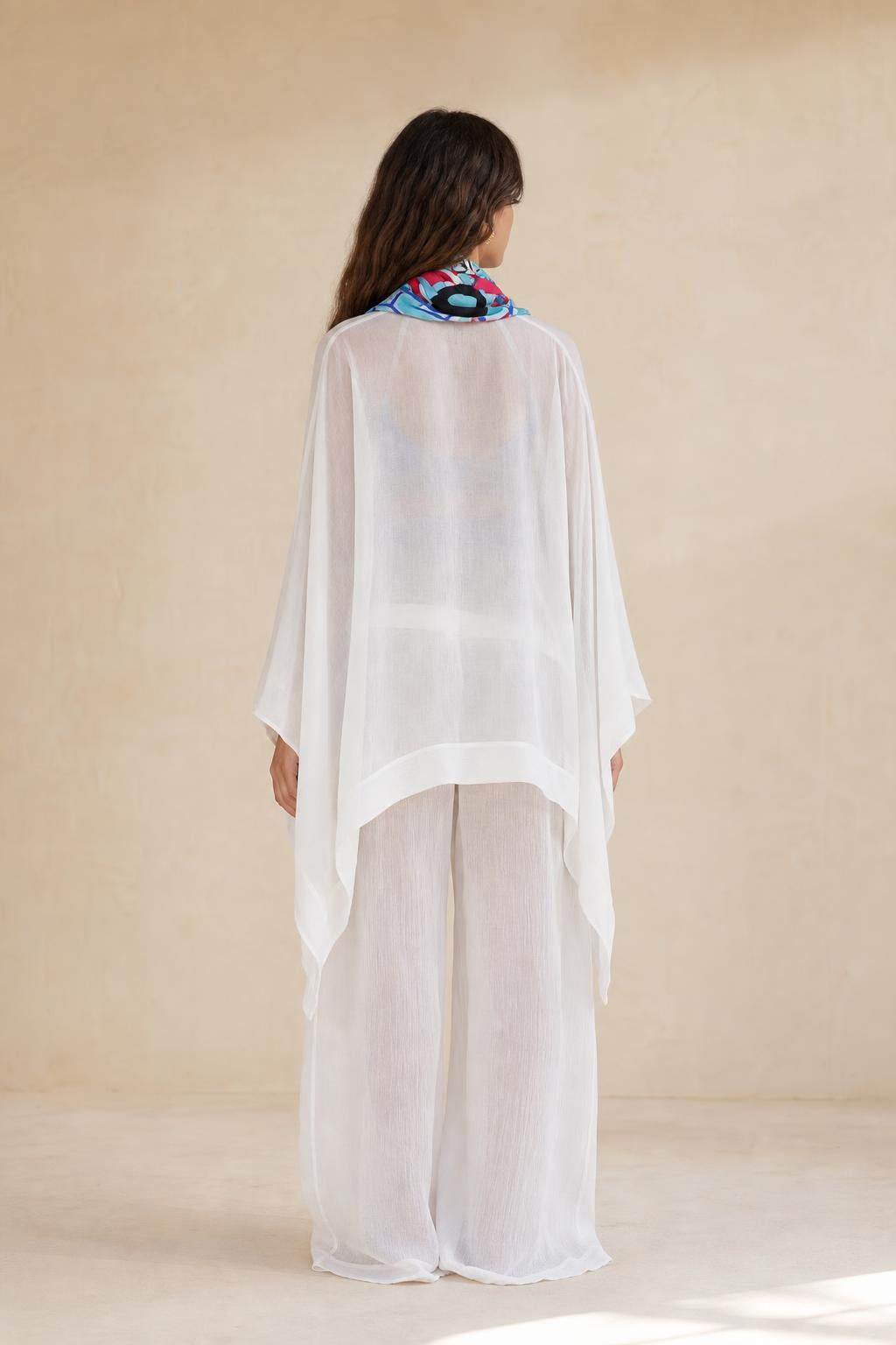 Back view of model in flowing white kaftan outfit