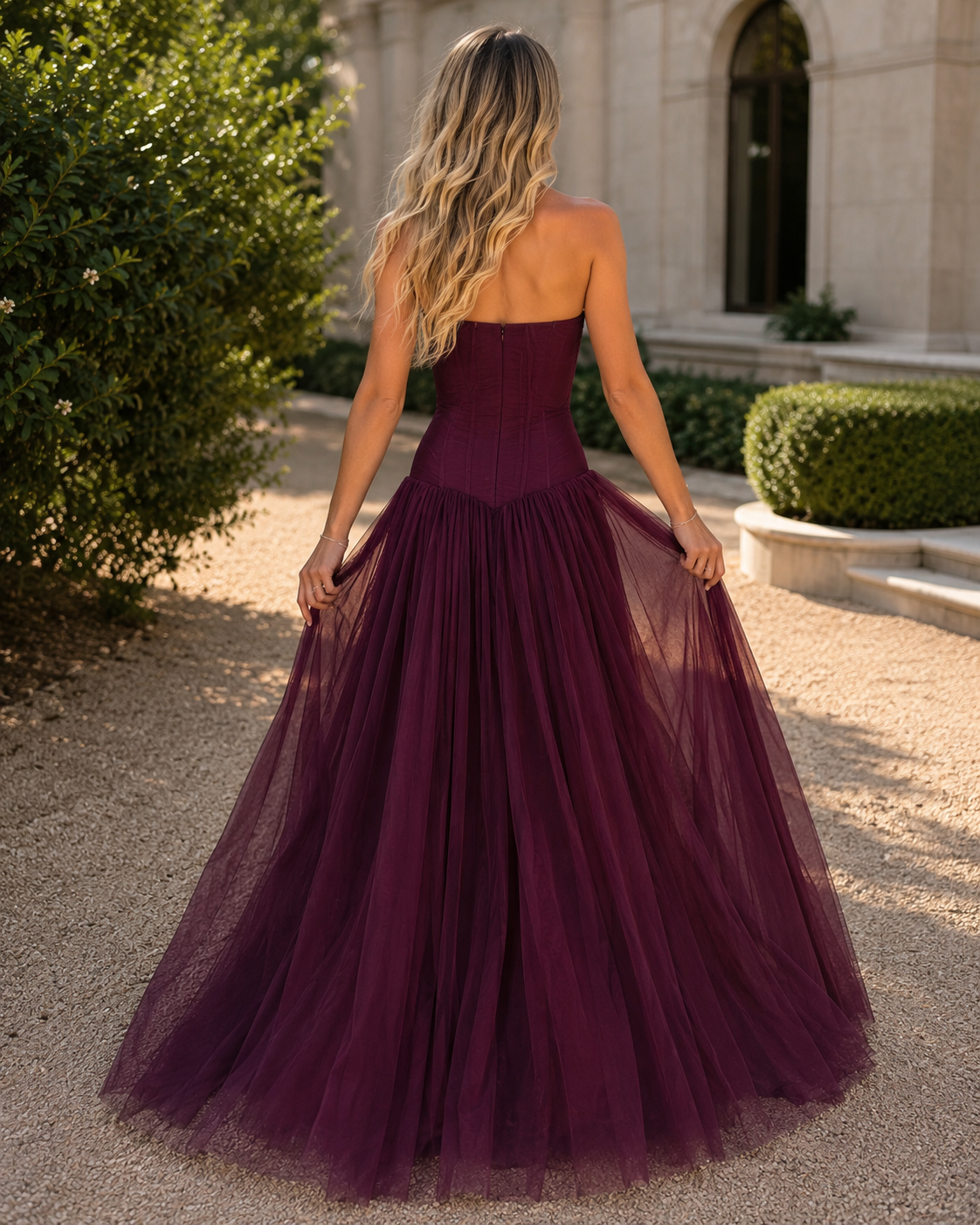 Back view of burgundy strapless formal tulle gown with full floor-length skirt