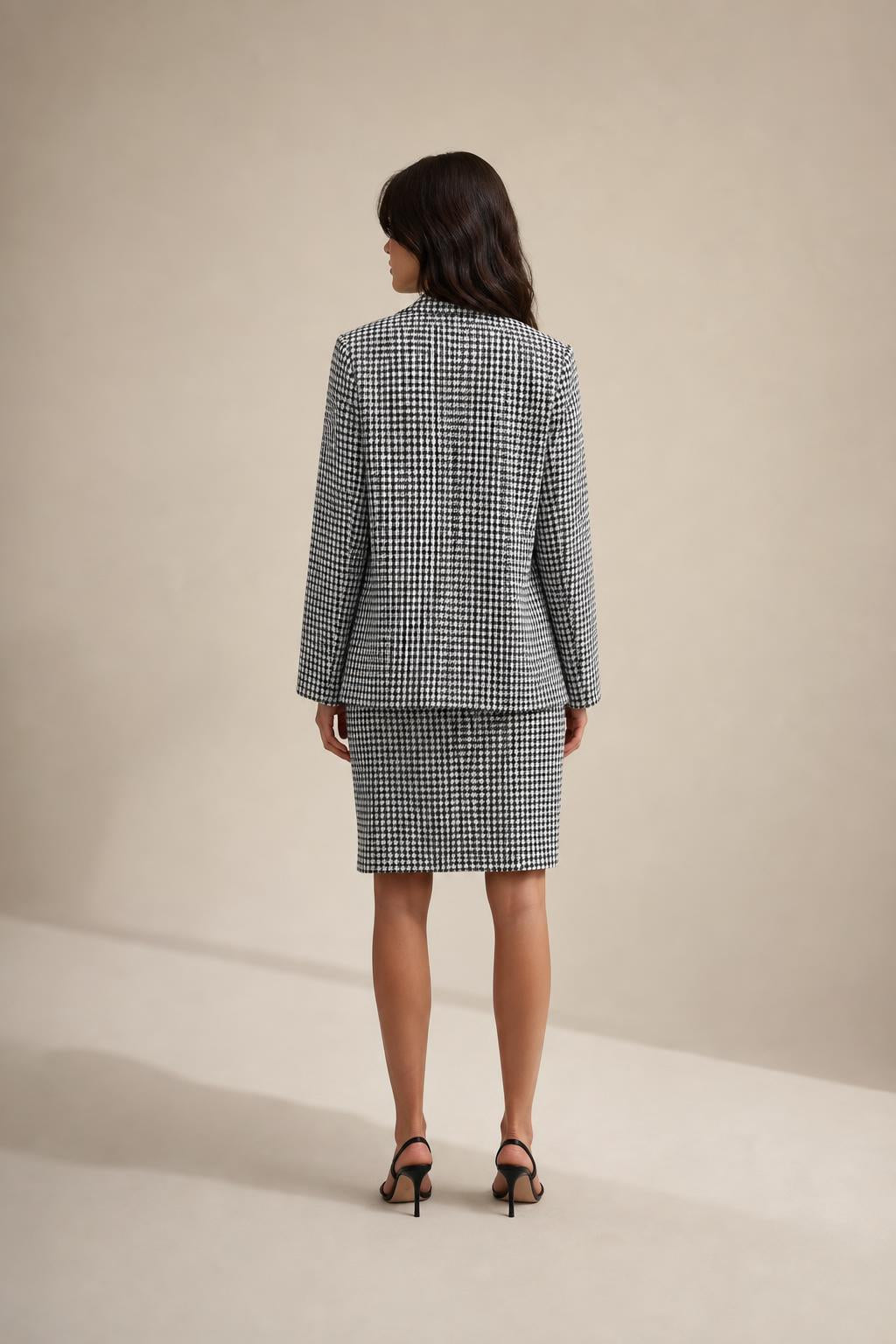 Back view of model wearing houndstooth blazer and skirt set