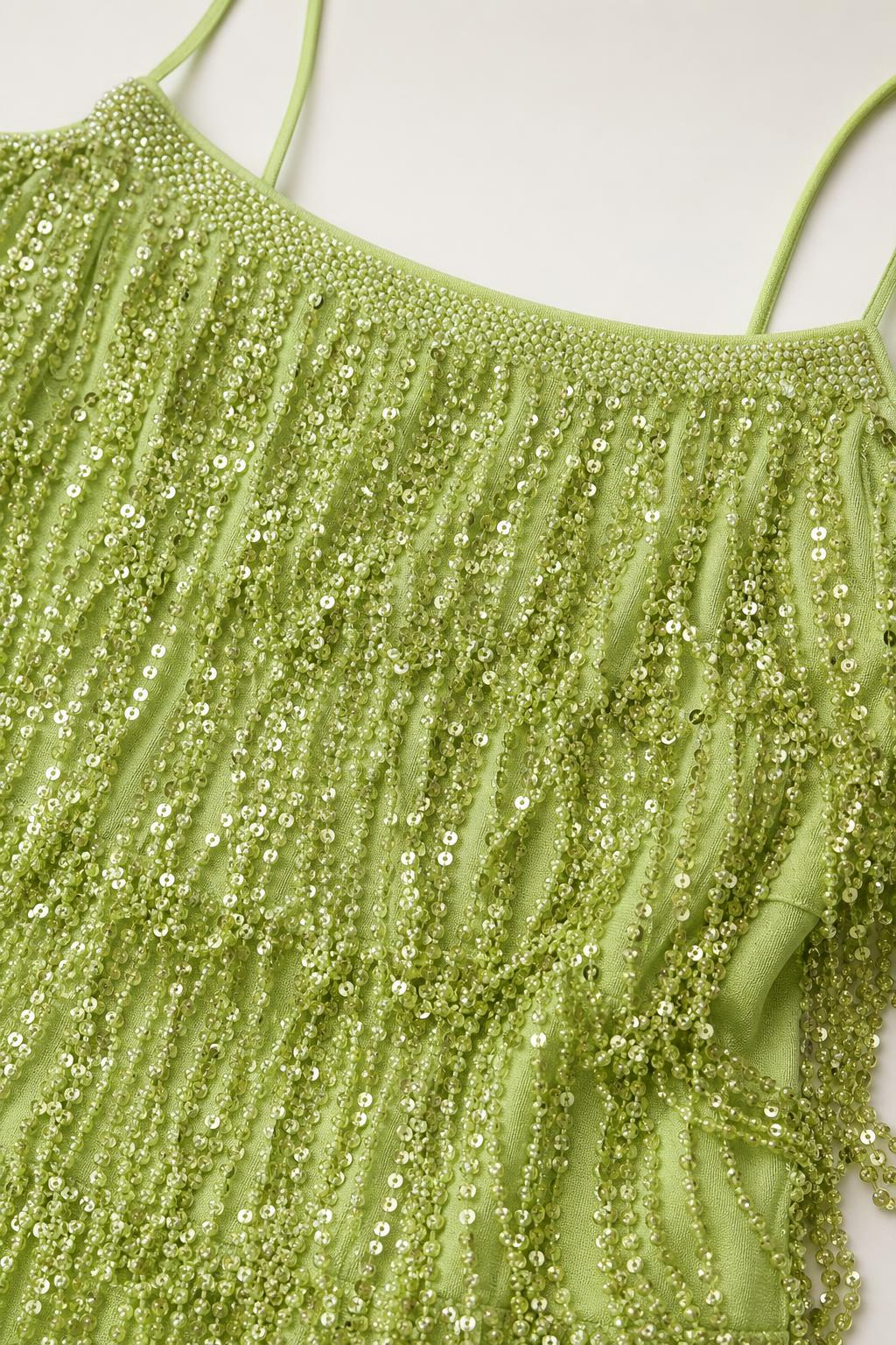 Close-up detail of green sequin and bead fringe texture