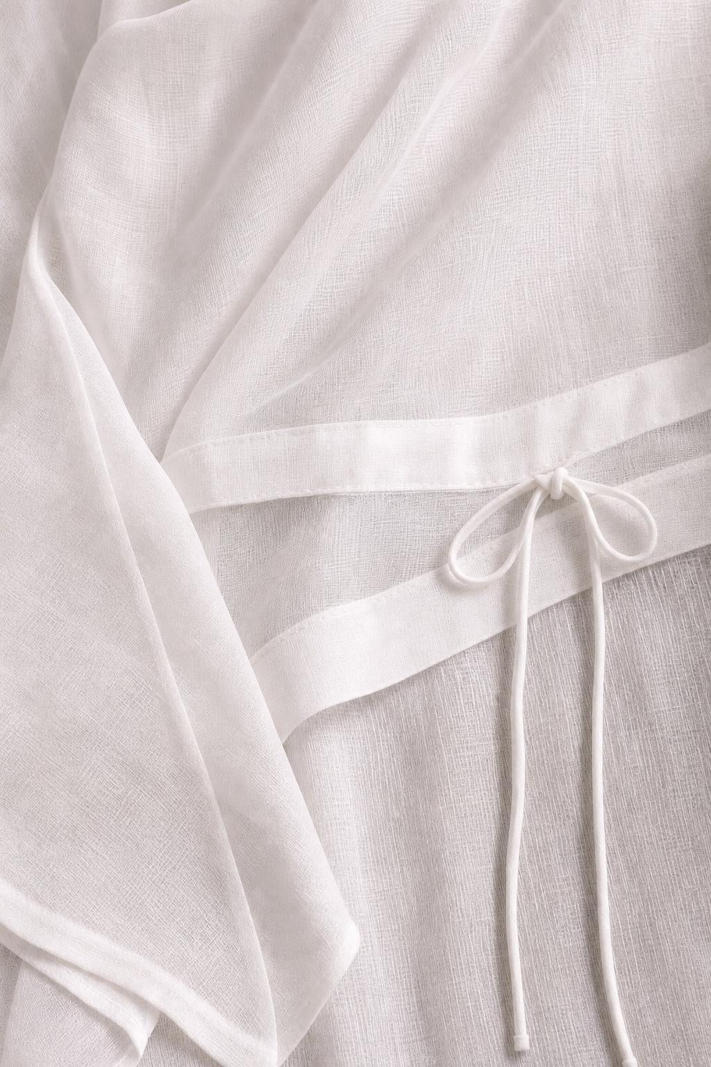 Close-up detail of white textured fabric and adjustable drawstring waist