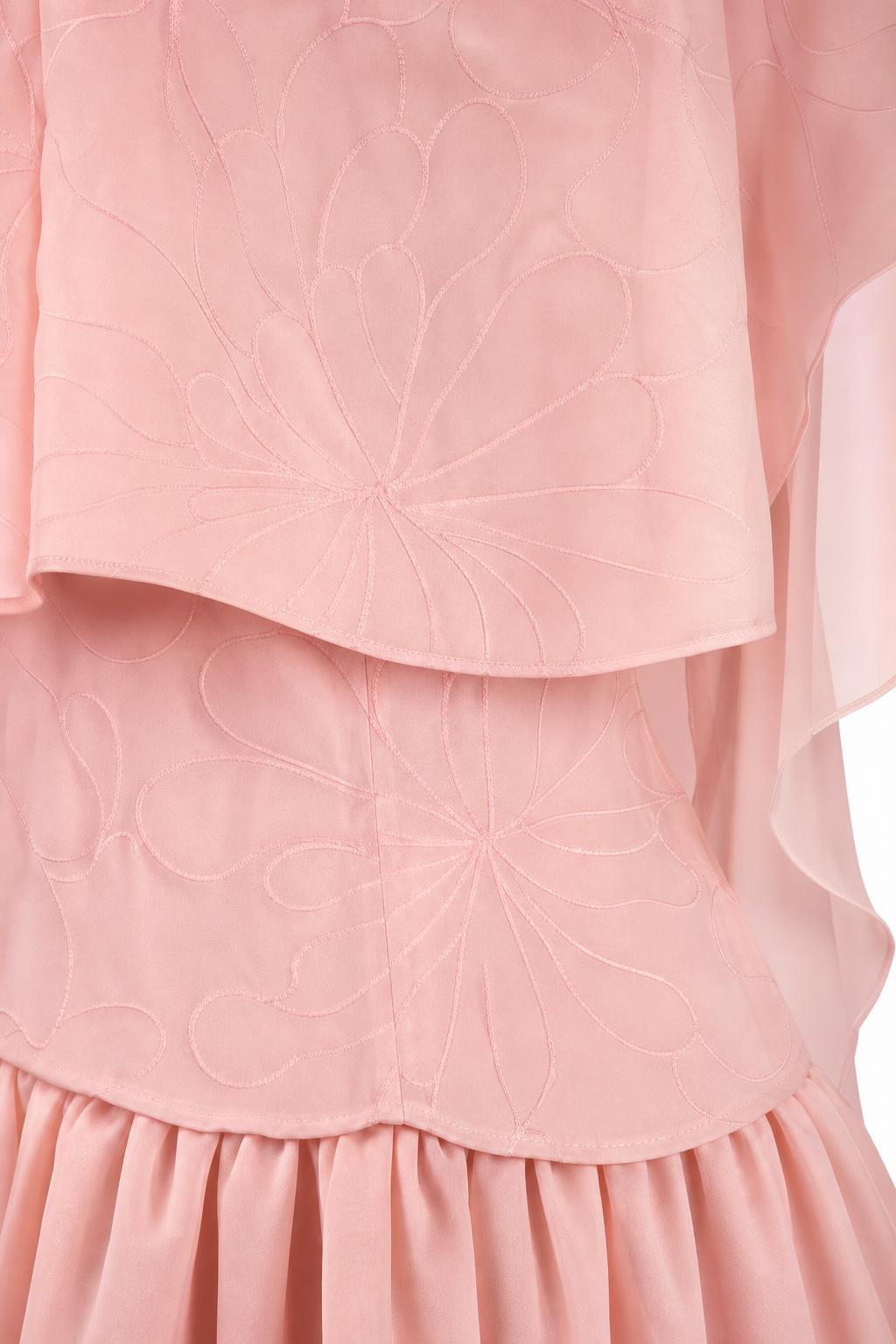 Close-up of embroidered cape overlay detail on pink dress