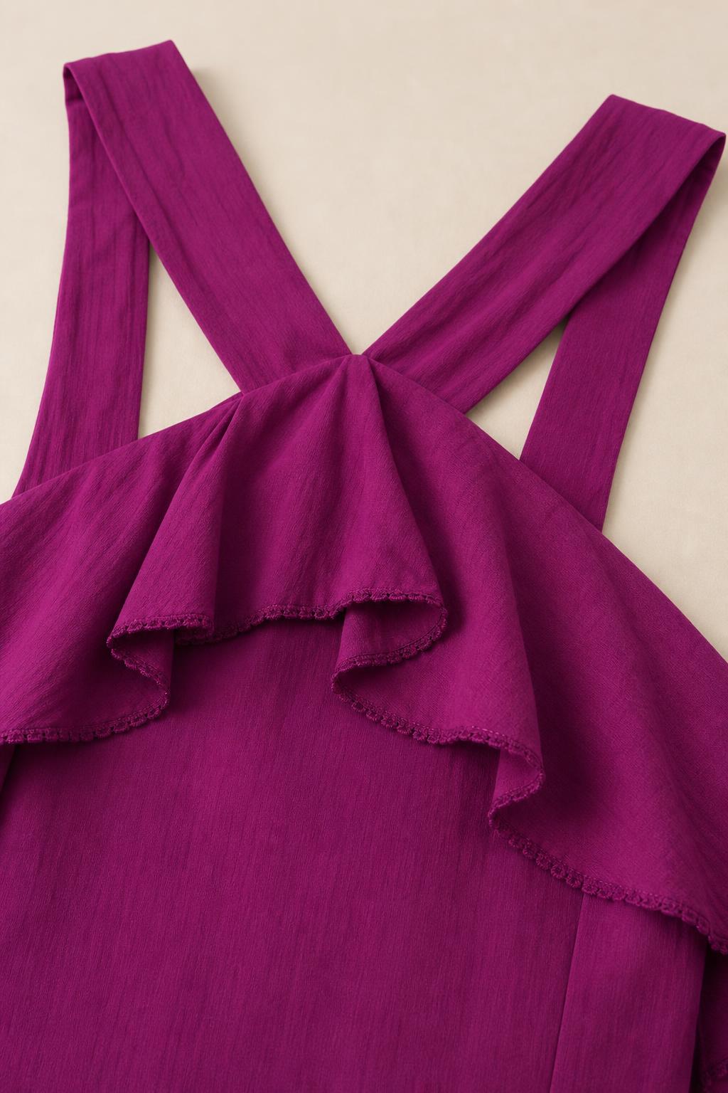 Close-up detail of halter neckline and ruffle trim on fuchsia dress