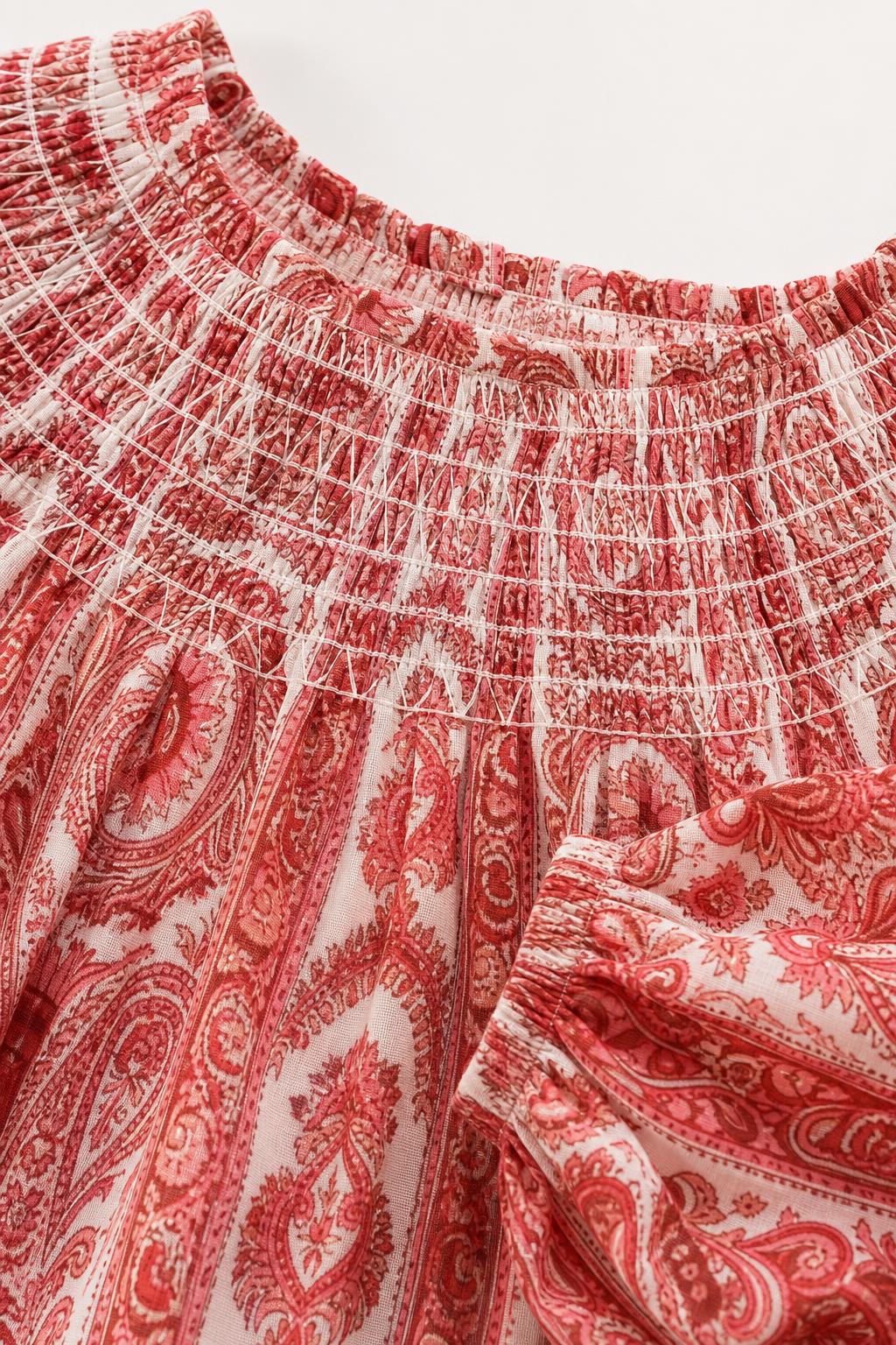 Close up of red paisley print smocked neckline