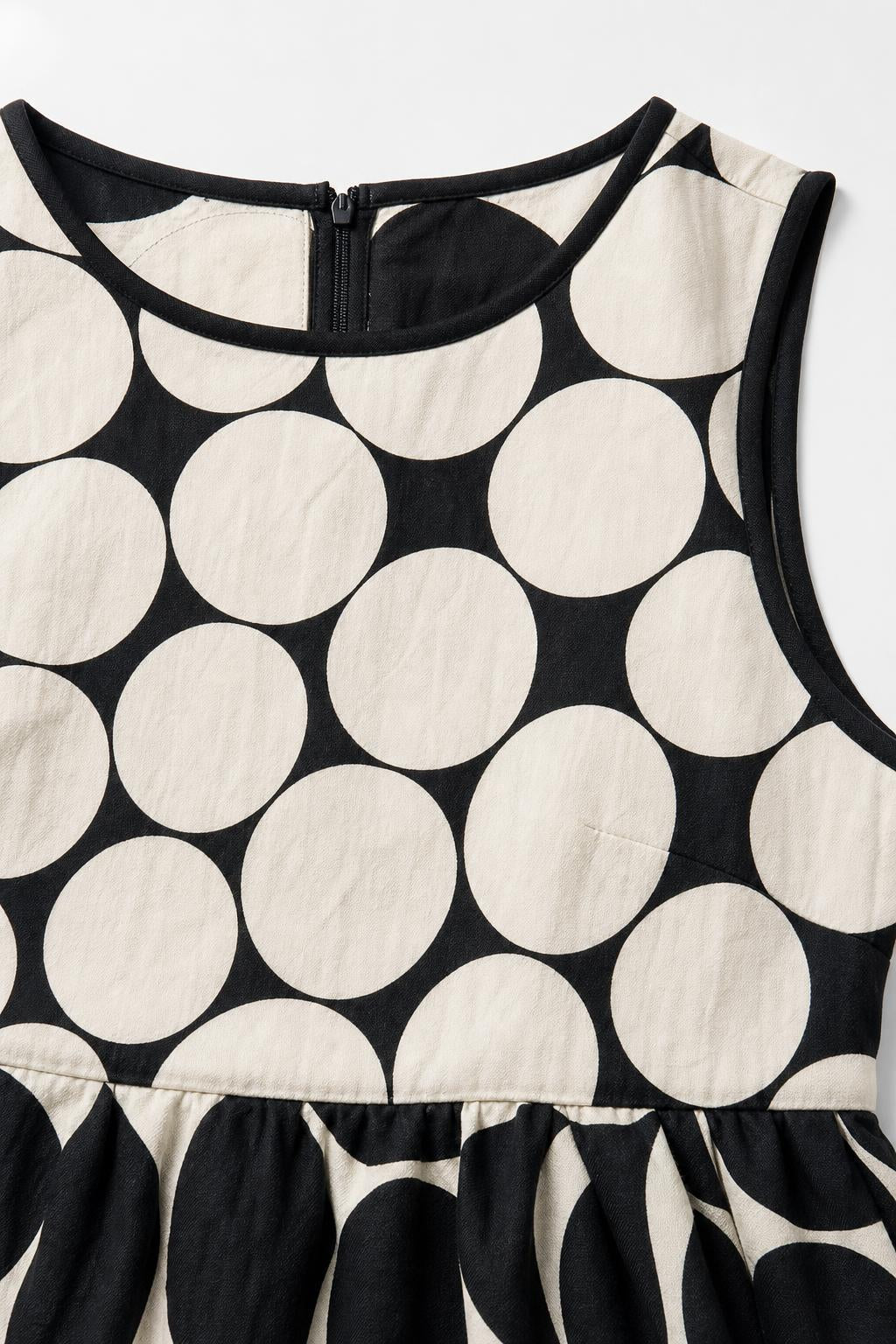 Close-up of neckline and fabric detail on black and white polka dot dress
