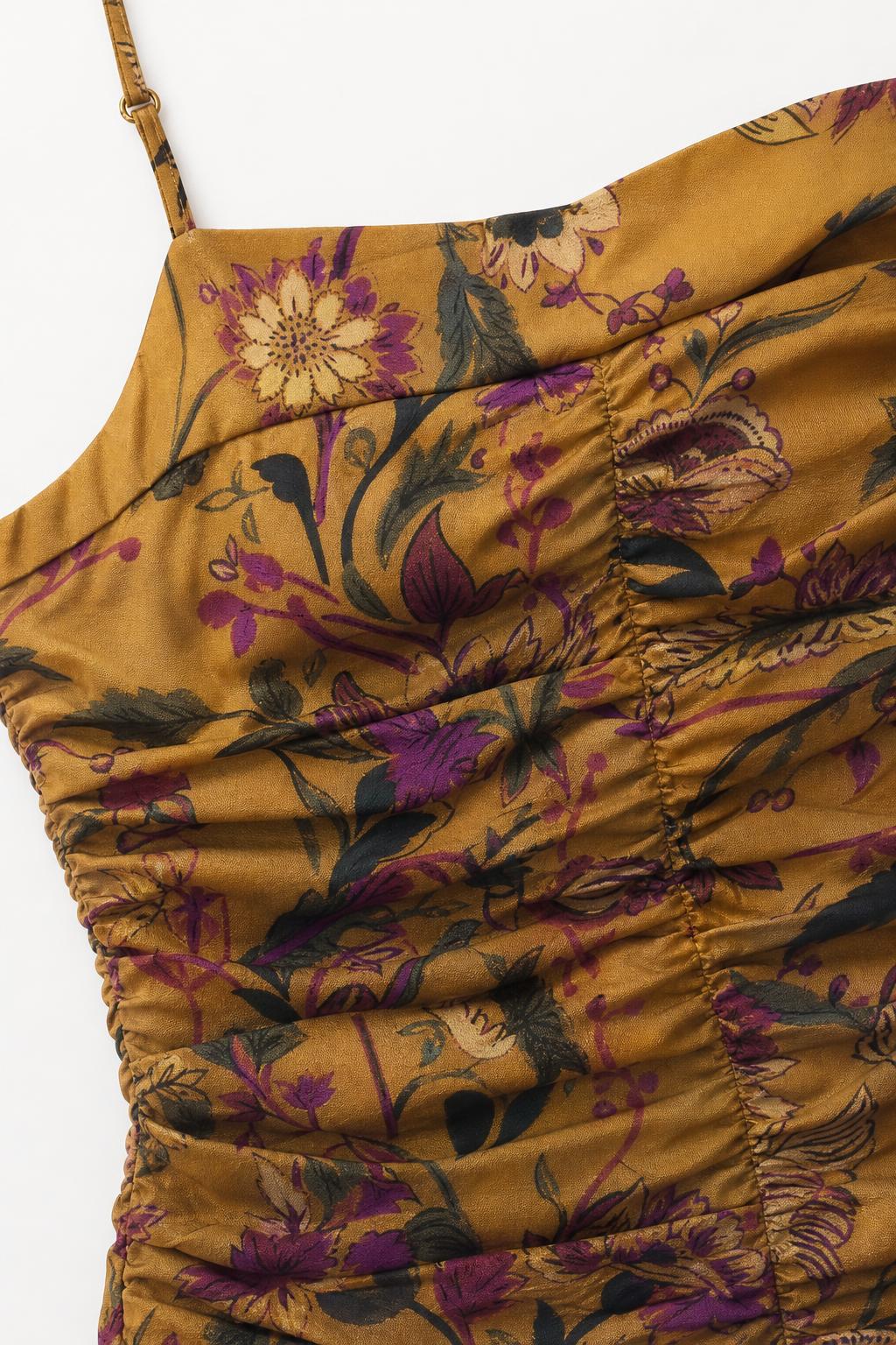 Close-up detail of ruching and floral pattern on mustard dress