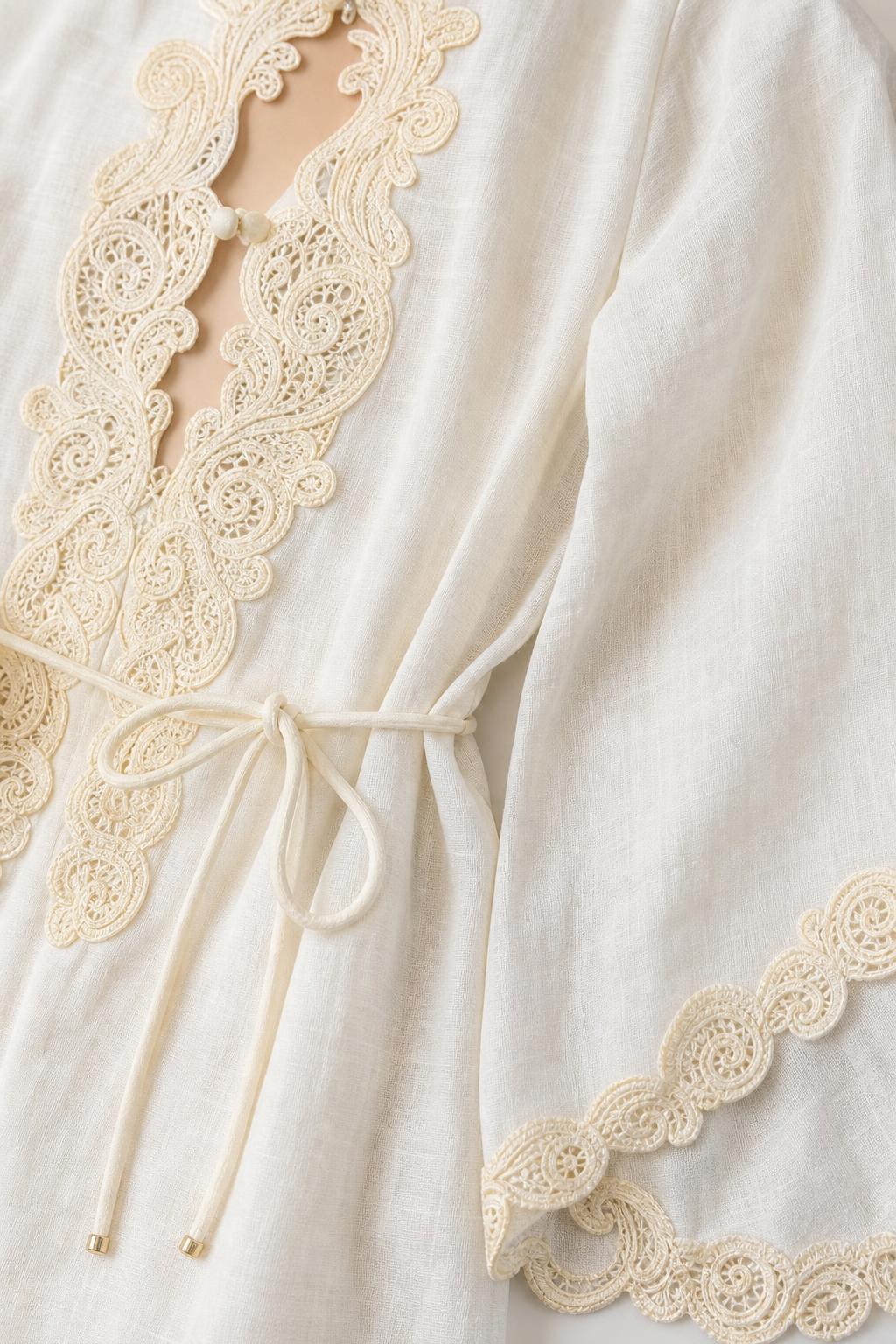 Closeup detail of crochet lace neckline, drawstring, and sleeve trim