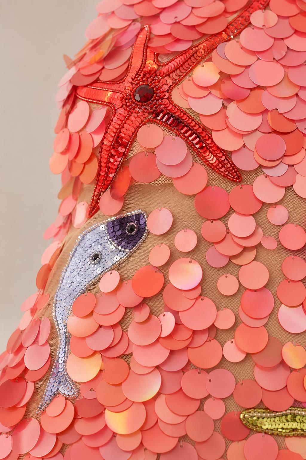 Close-up detail of starfish and fish beadwork on sequin dress