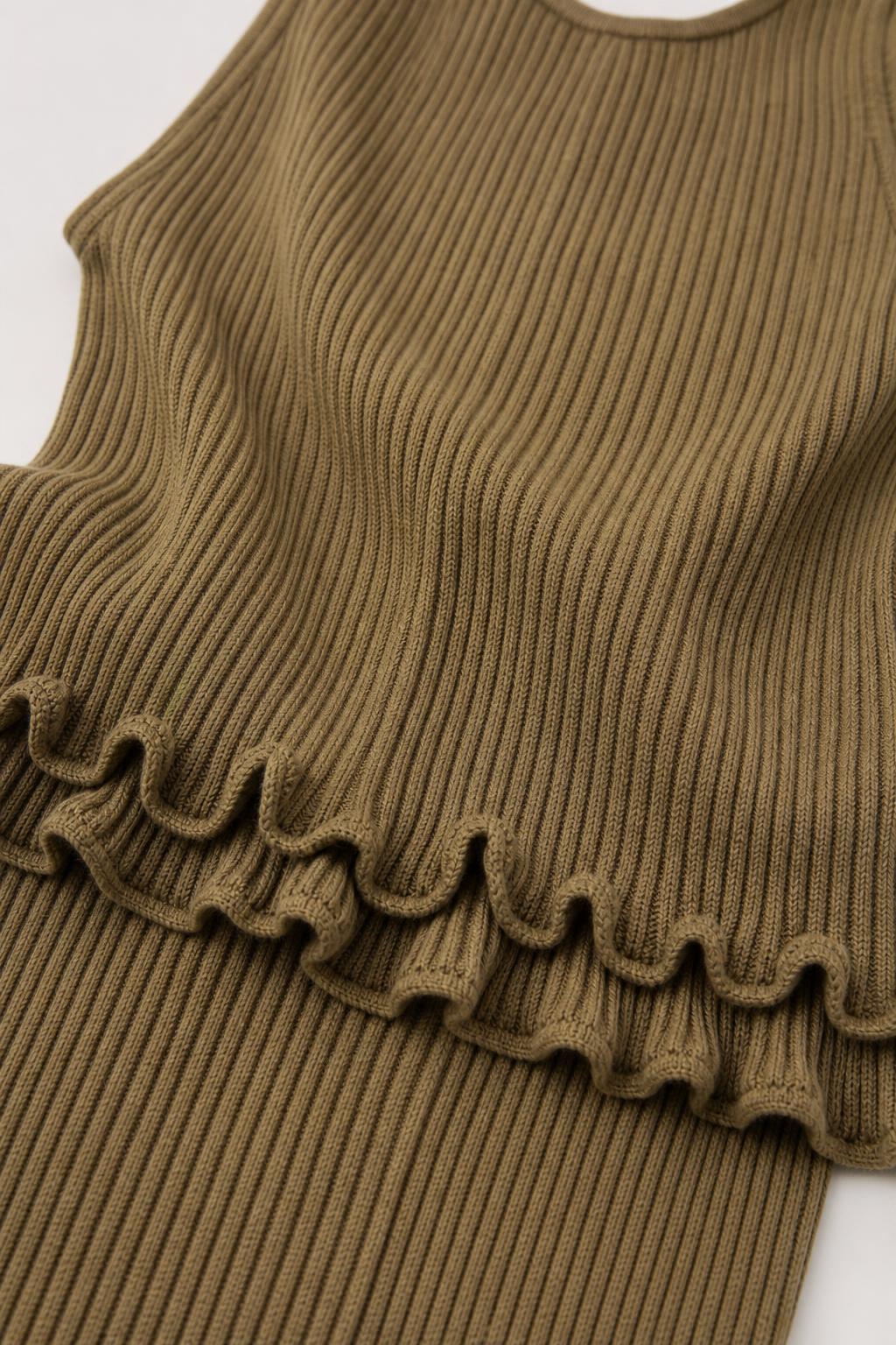 Close-up detail of lettuce-edge ruffle on olive knit fabric