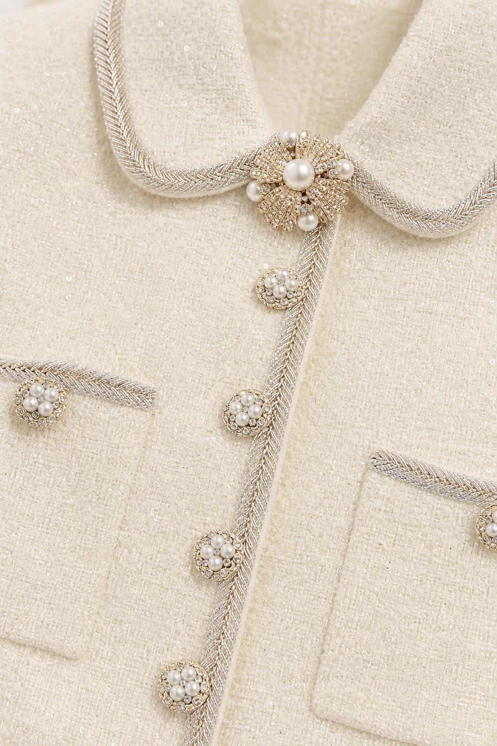Close-up detail of pearl buttons and collar on tweed dress