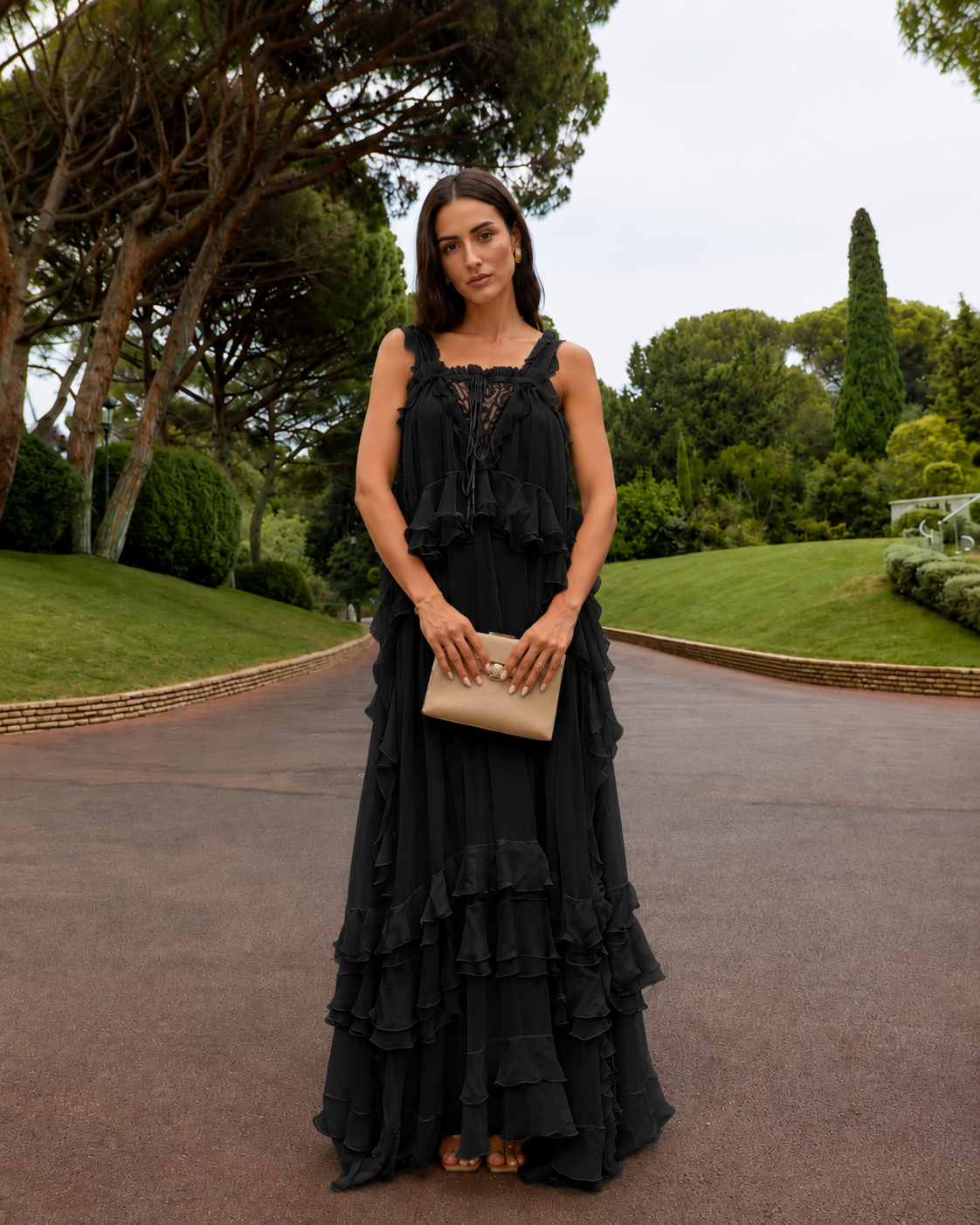Front view of black sleeveless tiered maxi dress with lace-look front detail