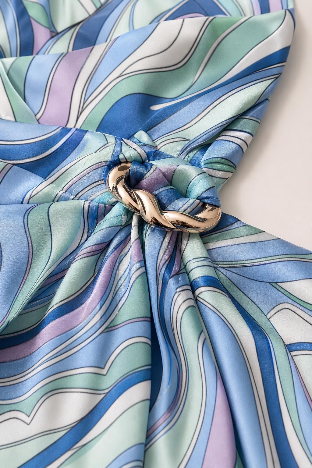 Close-up detail of fabric, abstract pattern, and metallic collar ring
