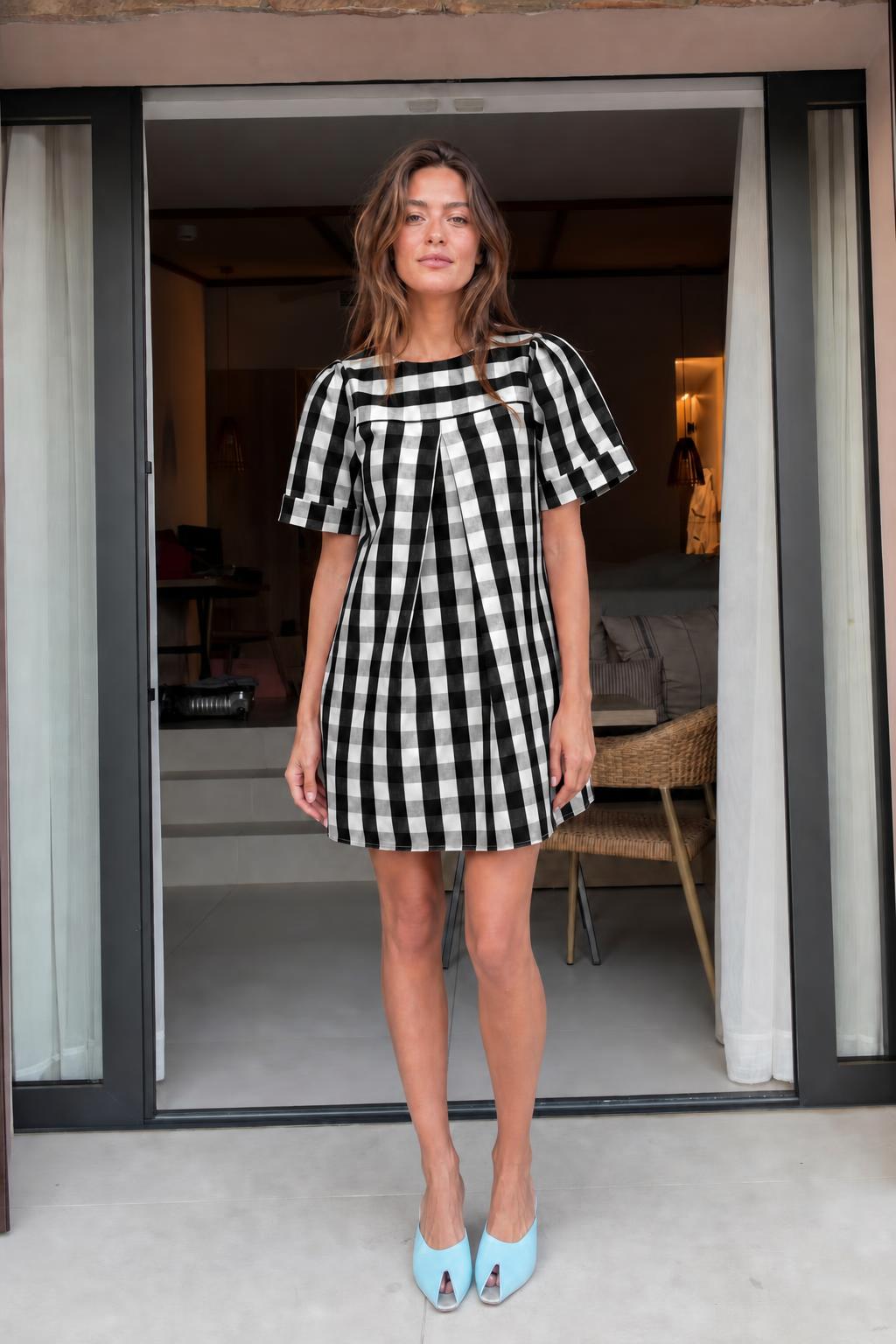 Front view of woman wearing black gingham check mini dress