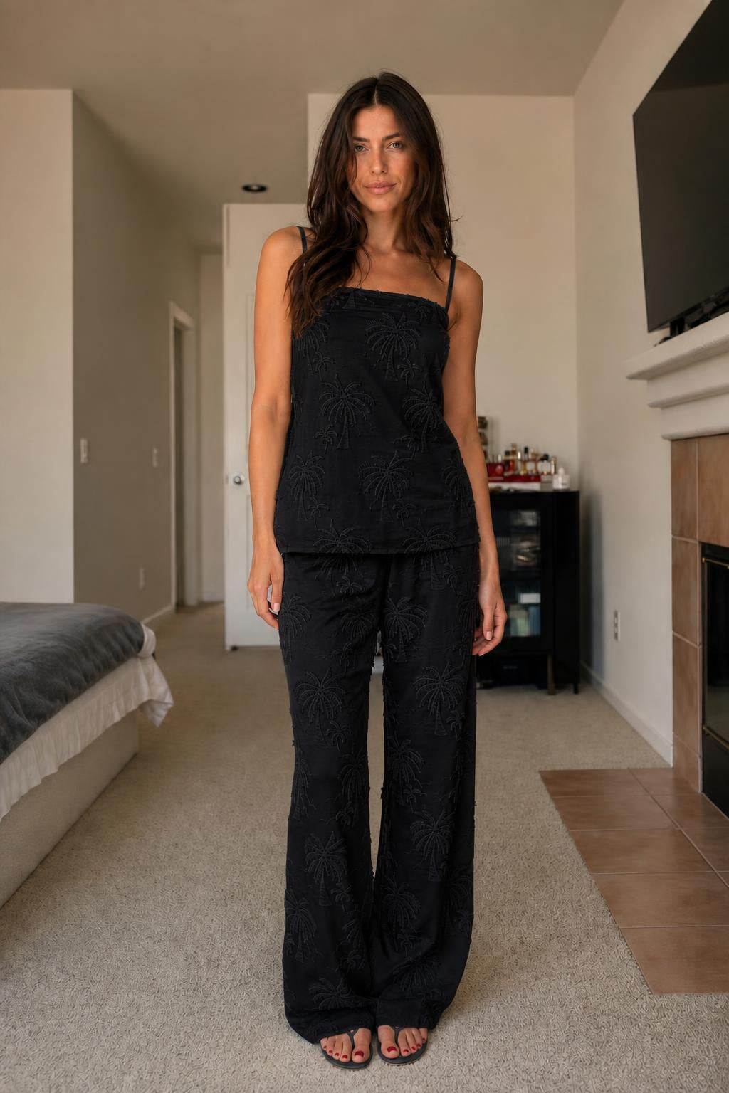 Front view of woman wearing black palm embroidered two-piece set