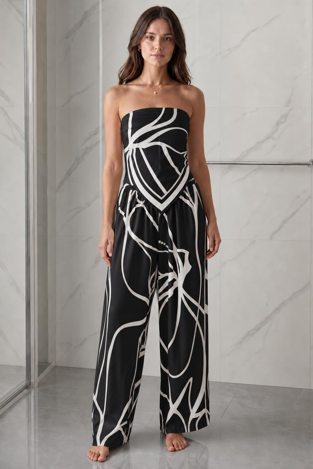 Woman wearing black and white abstract print strapless jumpsuit