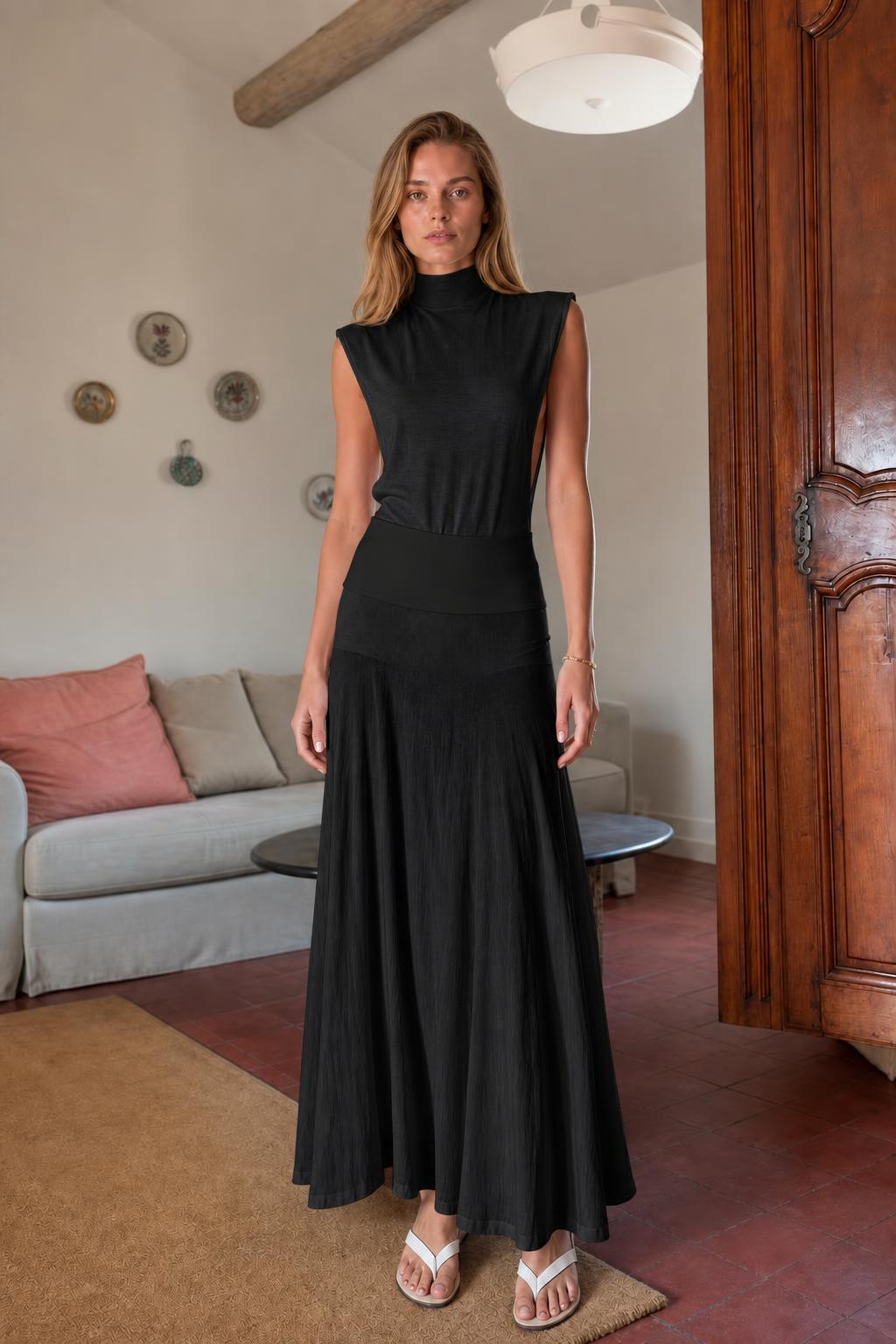 Model wearing black sleeveless mock neck knit maxi dress