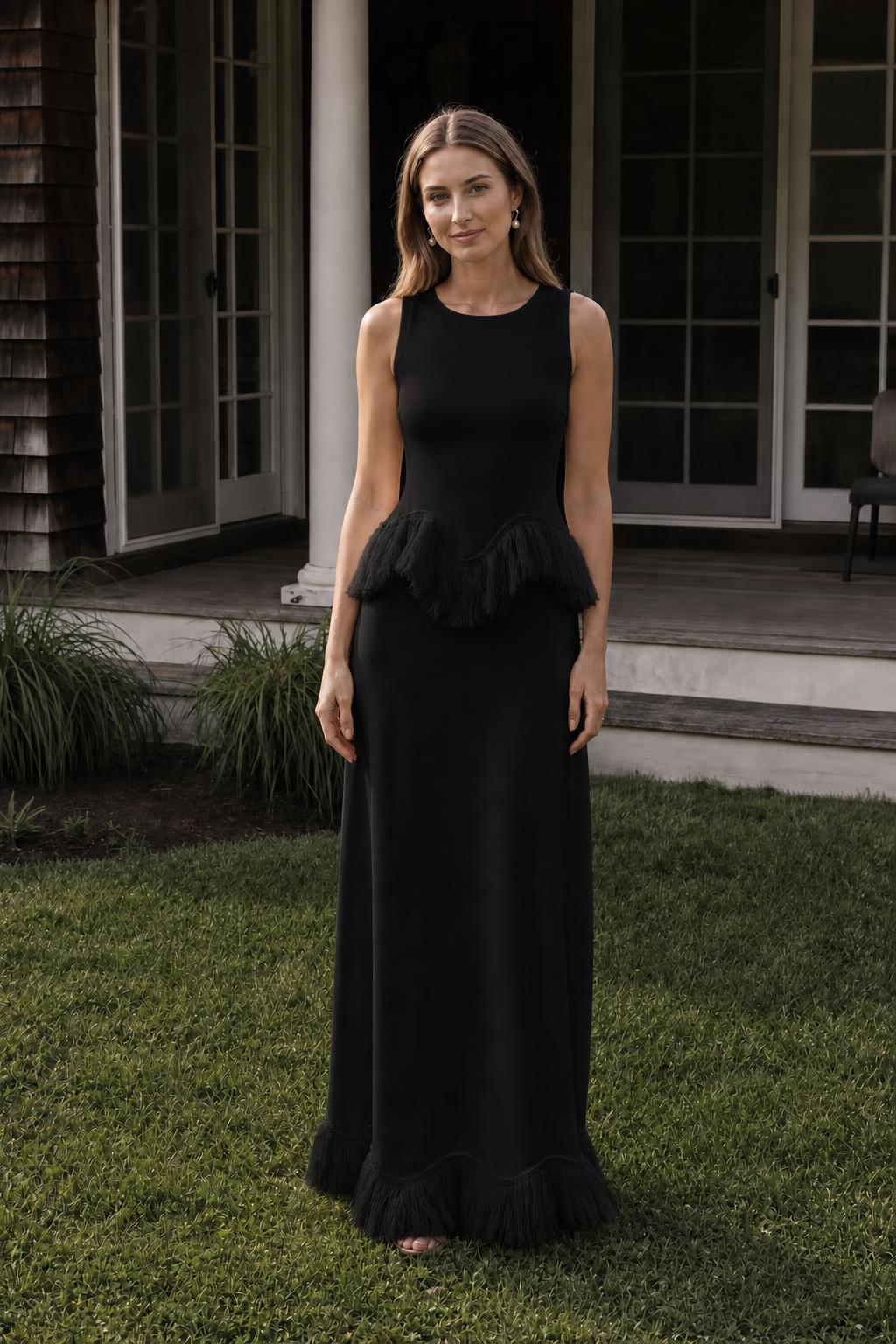 Front view of model wearing black fringed peplum maxi dress