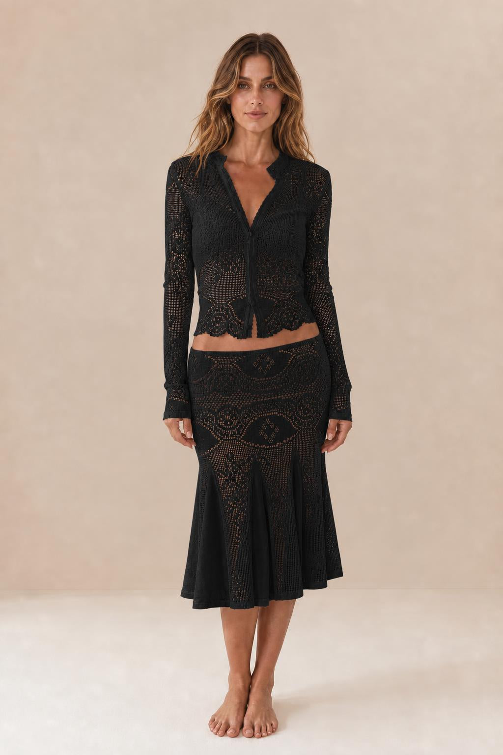 Front view of woman wearing black crochet lace two-piece set