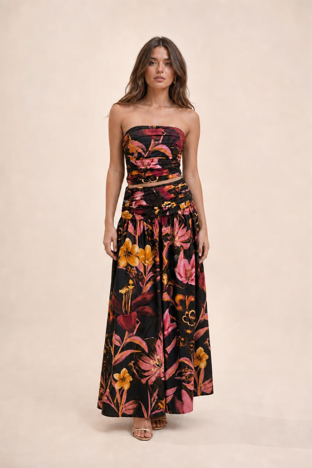Model wearing black floral strapless crop top and maxi skirt set