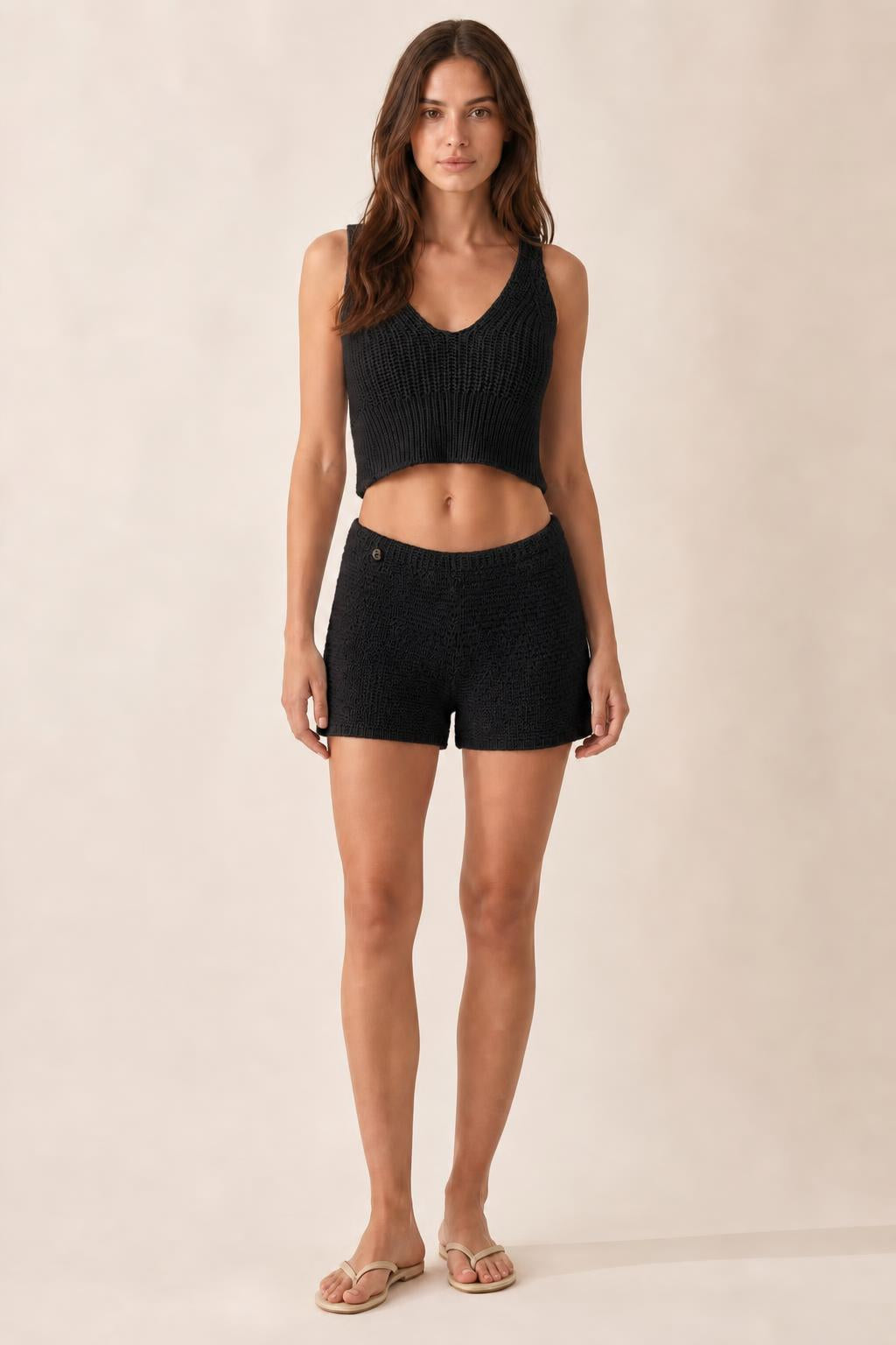 Model wearing black ribbed knit crop tank and shorts set
