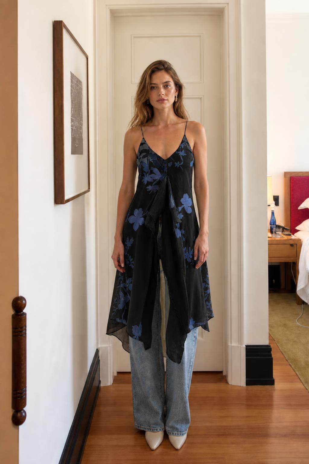 Model wearing black floral cami dress over denim