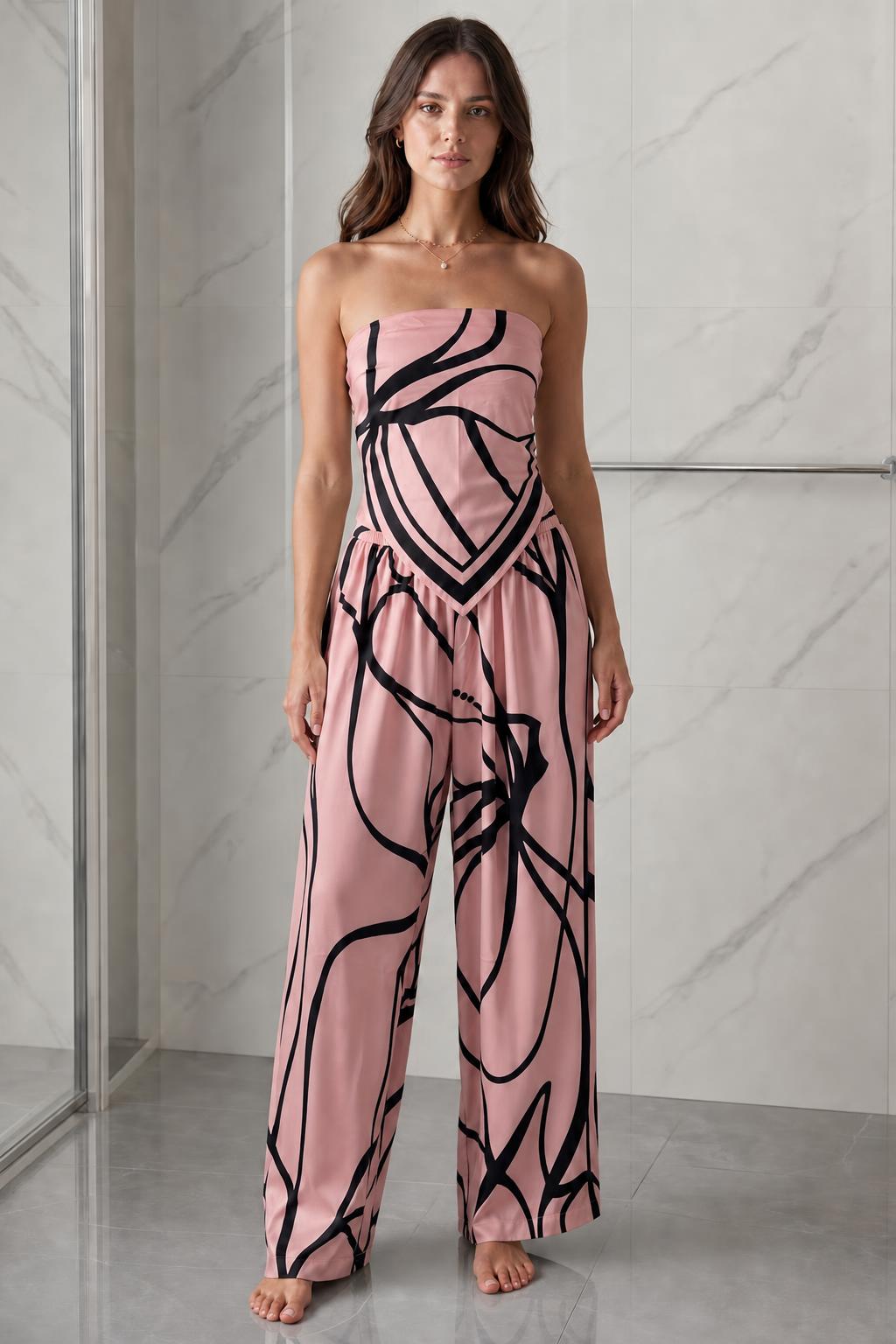 Woman wearing pink and black abstract print strapless jumpsuit