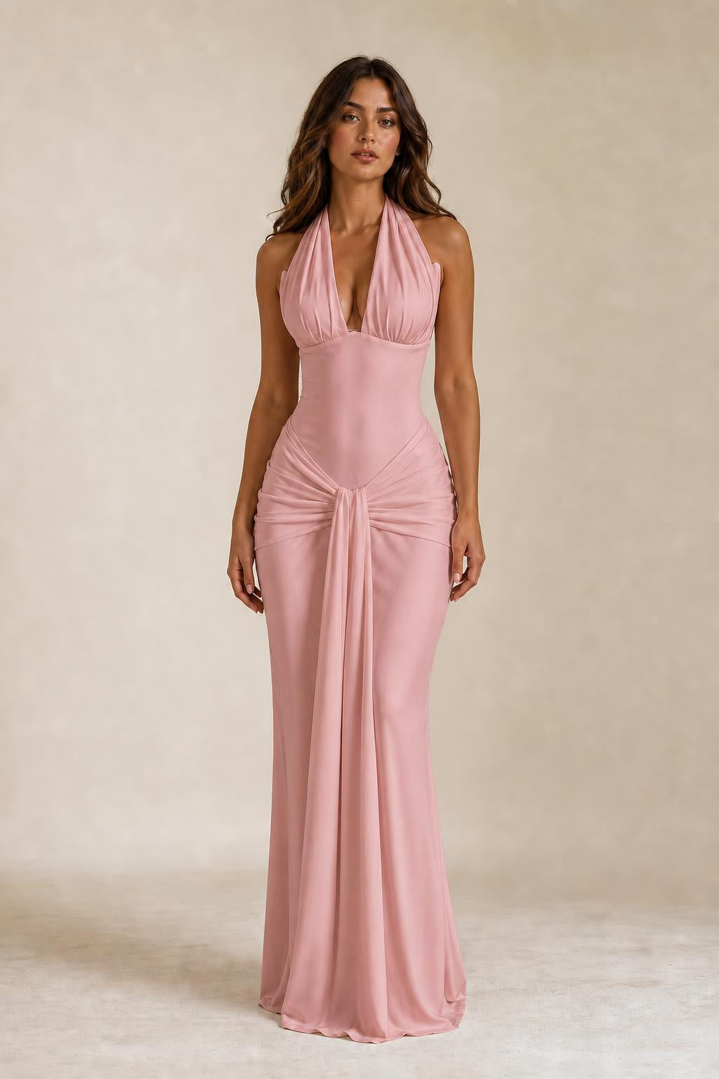 Front view of woman wearing pink draped halter neck maxi dress