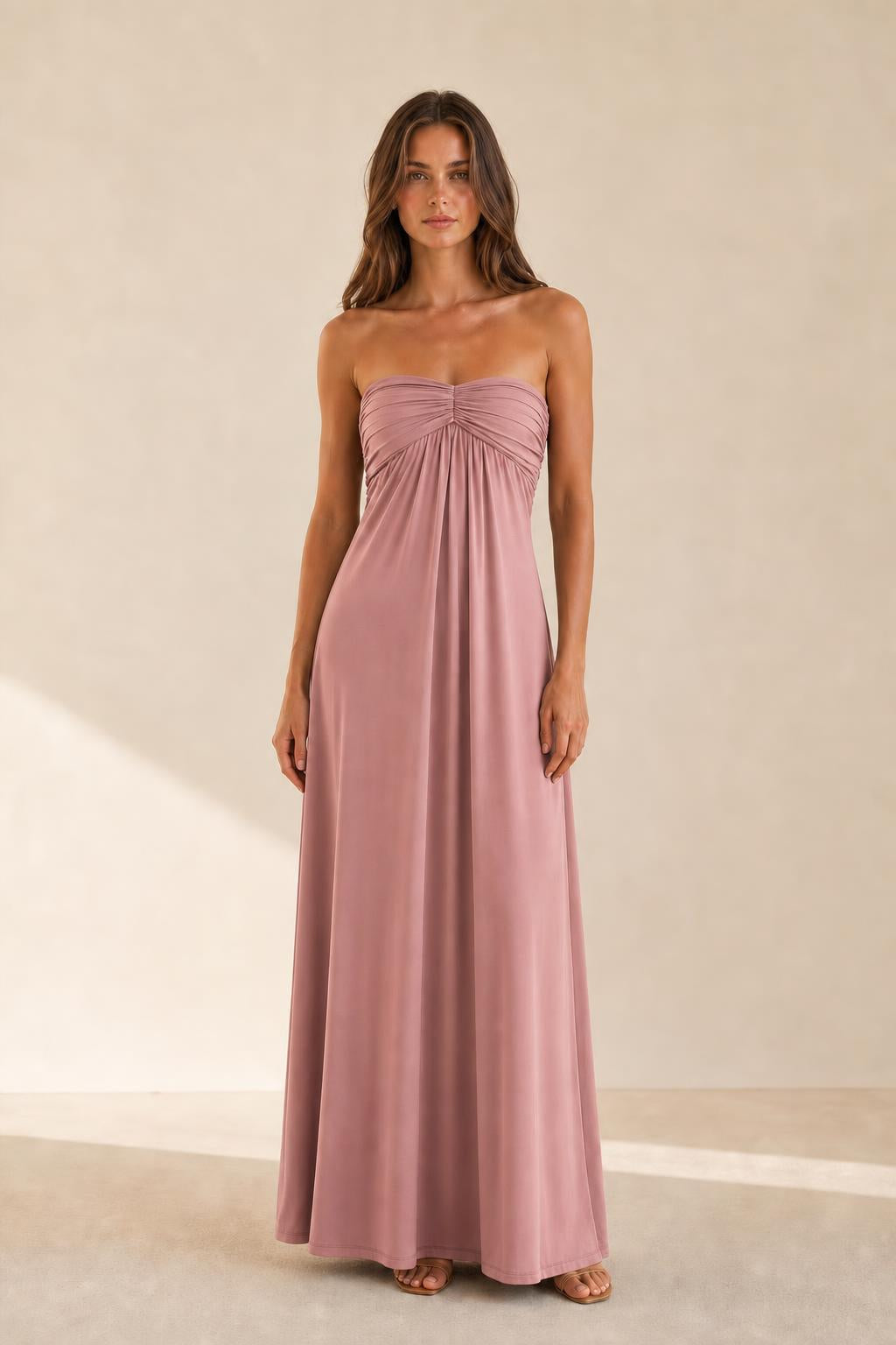 Woman wearing dusty rose strapless ruched maxi dress front view