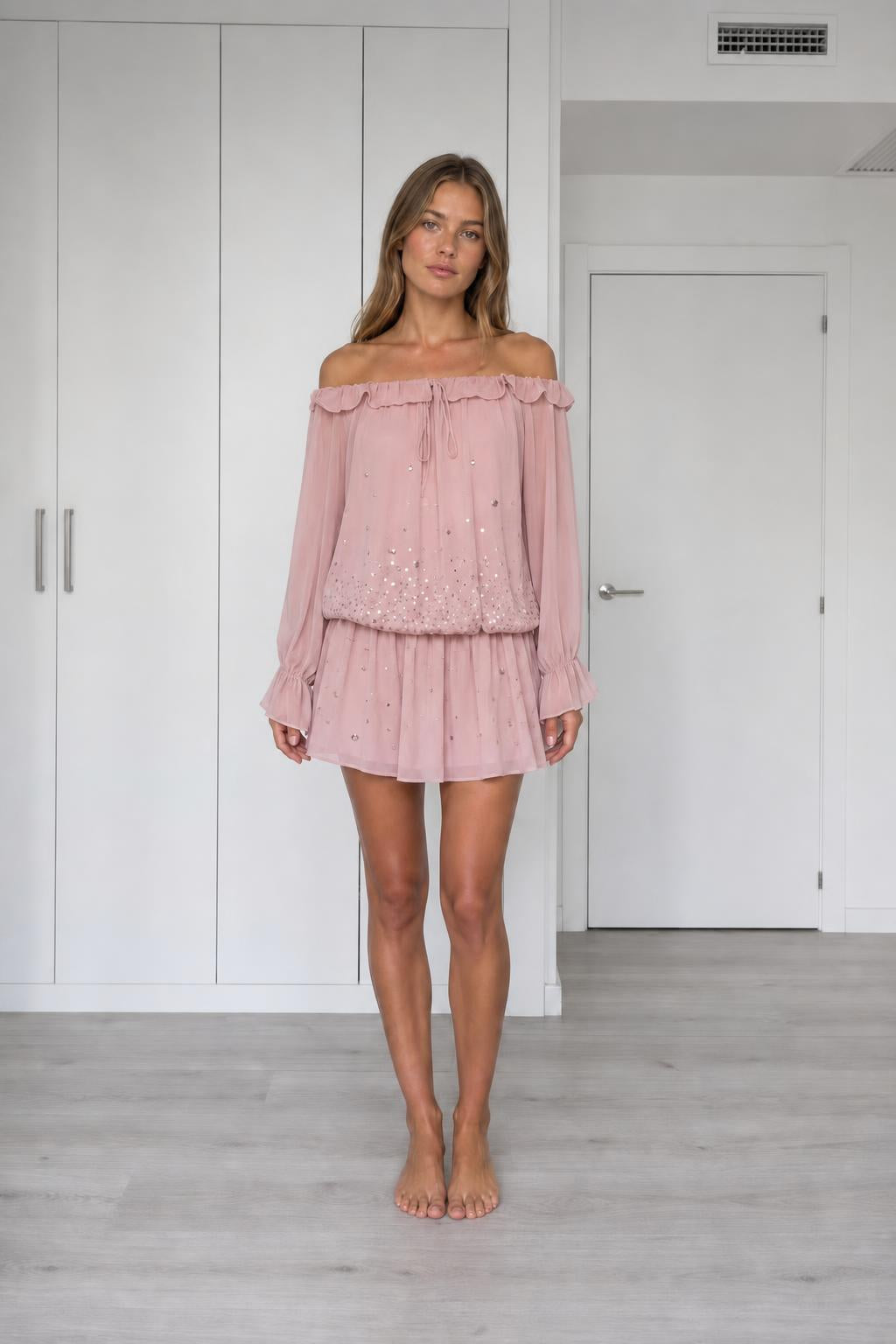 Front view of model wearing pink off-the-shoulder chiffon mini dress