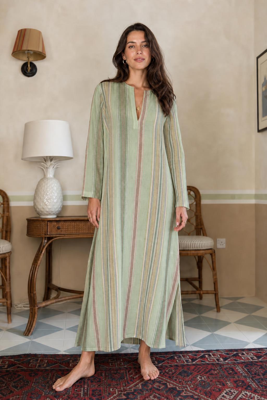 Model wearing sage green vertical stripe long sleeve maxi dress