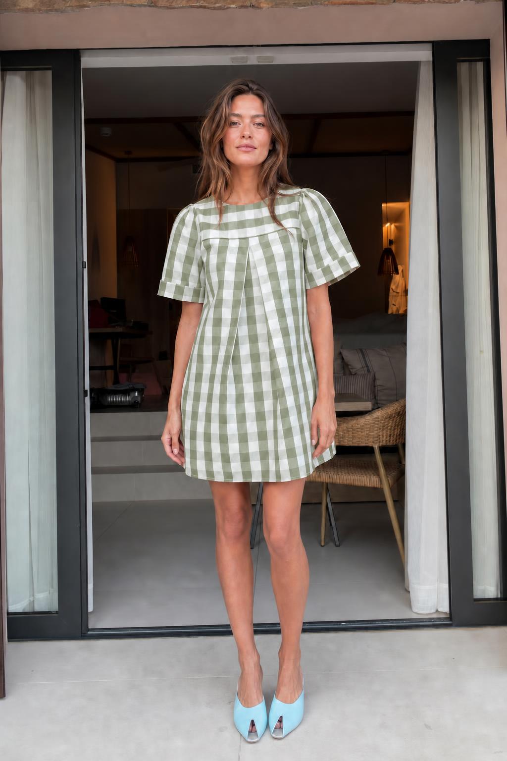 Front view of woman wearing green gingham check mini dress