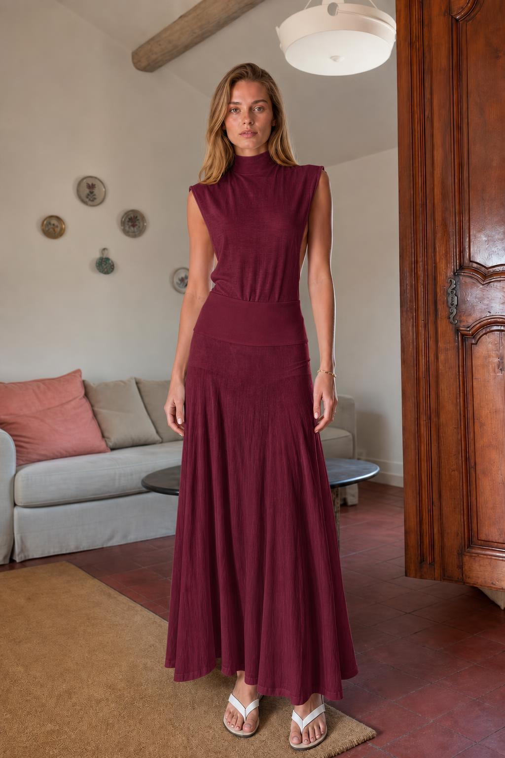 Model wearing burgundy sleeveless mock neck knit maxi dress